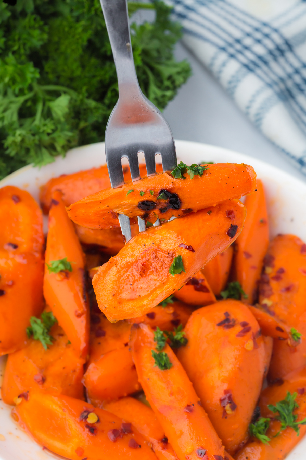 A forkful of carrots held above a bowlful