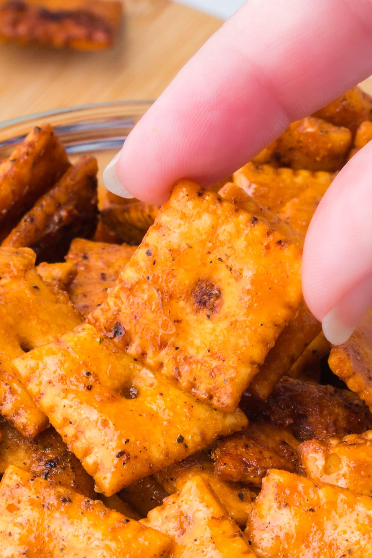 A bowl of crackers with one being held in the air