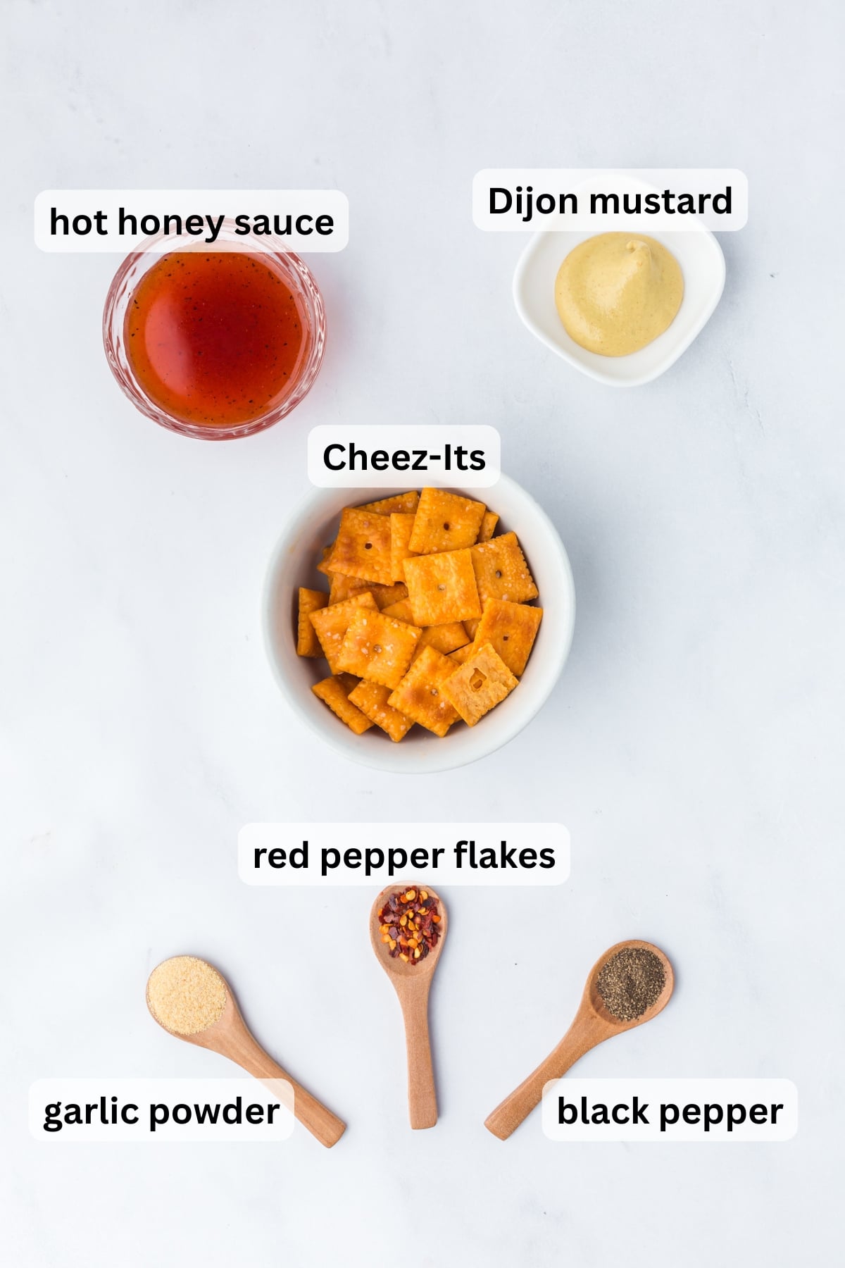 ingredients for hot honey cheez its including hot honey dijon mustard and crackers in bowls on a table