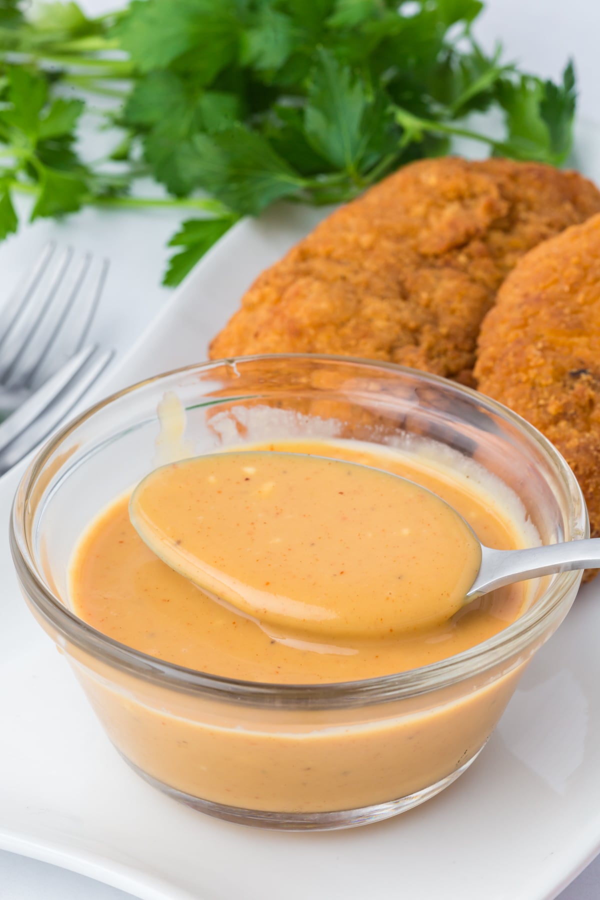 A spoonful of sauce being lifted out of a bowlful.