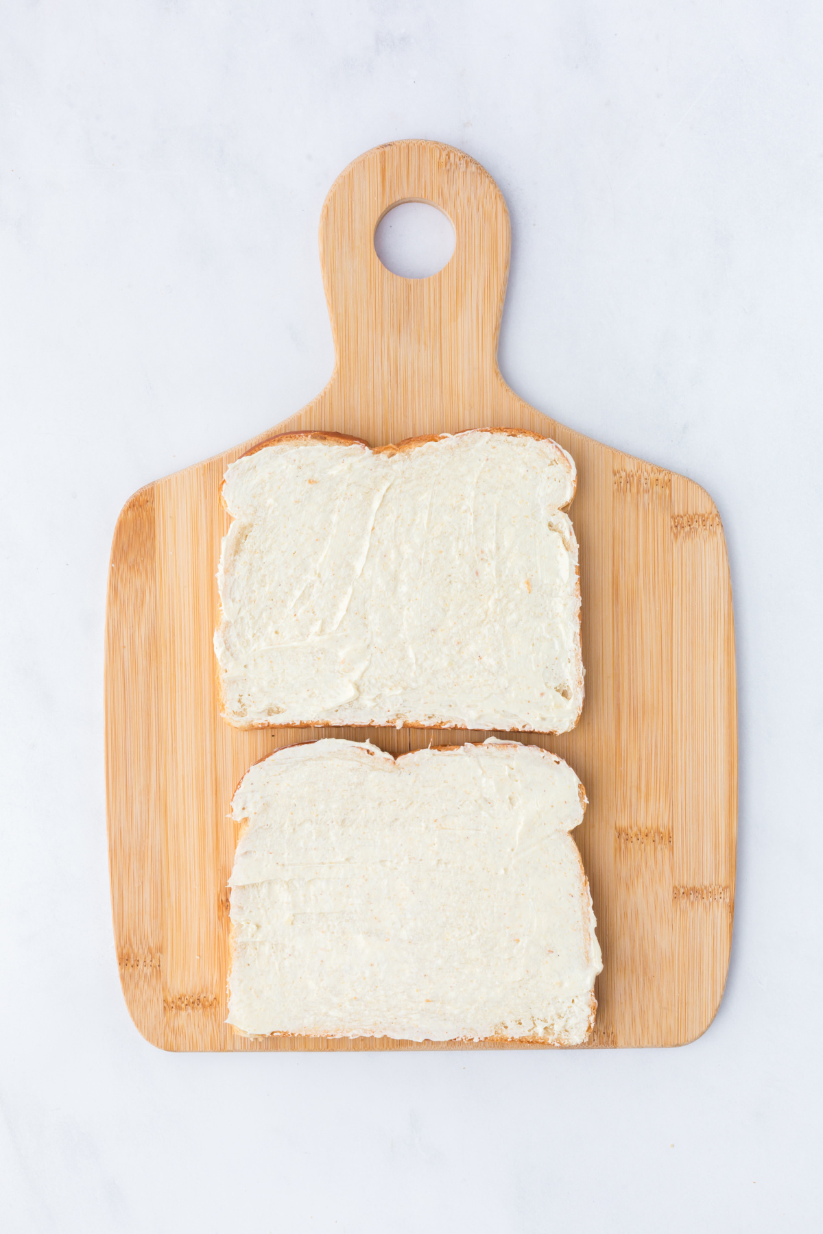two slices of buttered bread on a cutting board