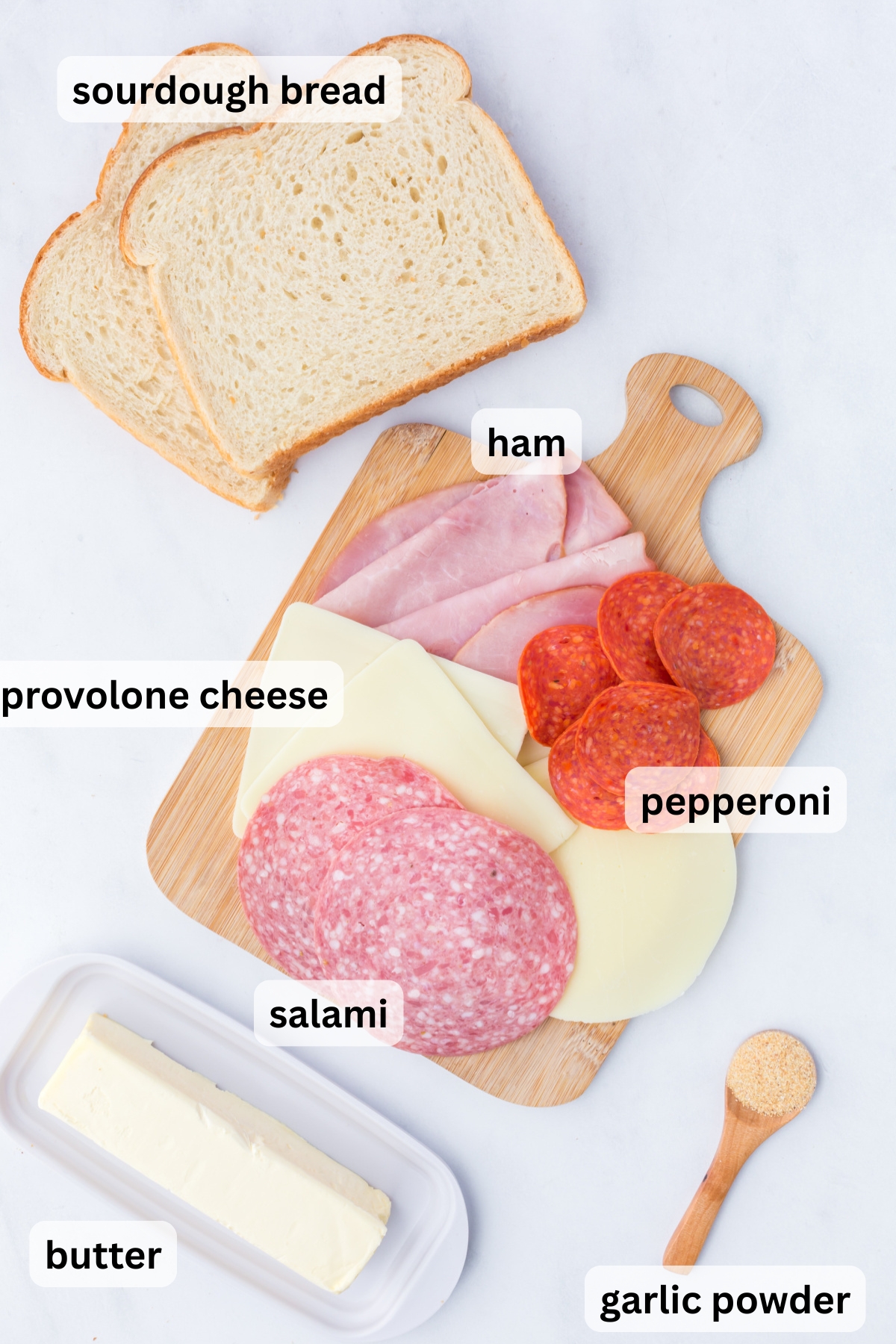 All of the ingredients needed to make Italian Grilled Cheese on cutting boards on a table.