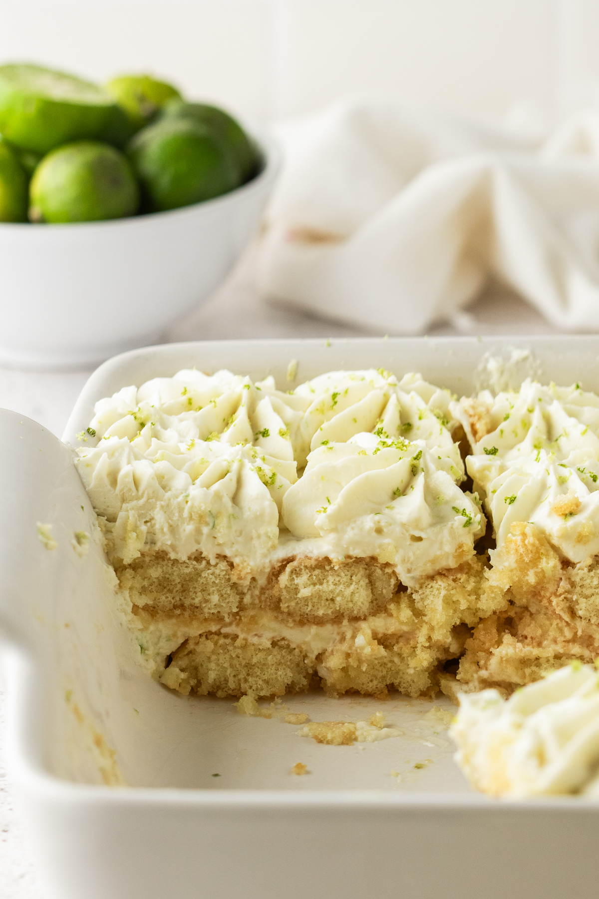 Tiramisu in a casserole dish with slices missing.