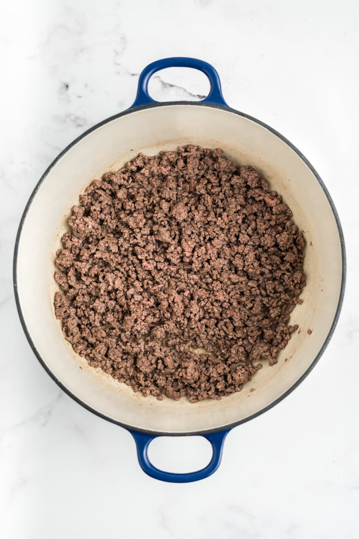 Ground beef cooking in a skillet.