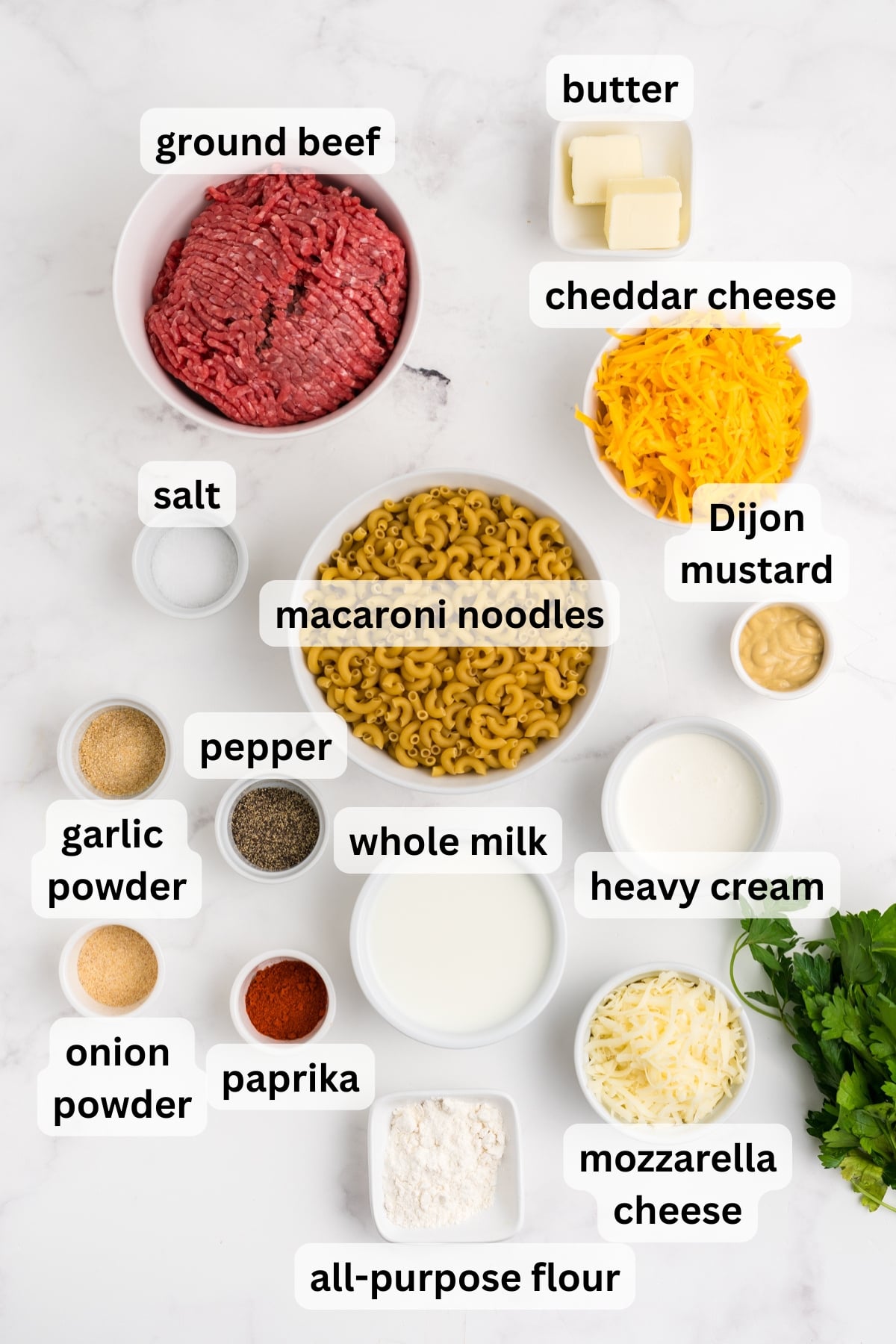 Ingredients to make this ground beef mac and cheese in bowls on a table.