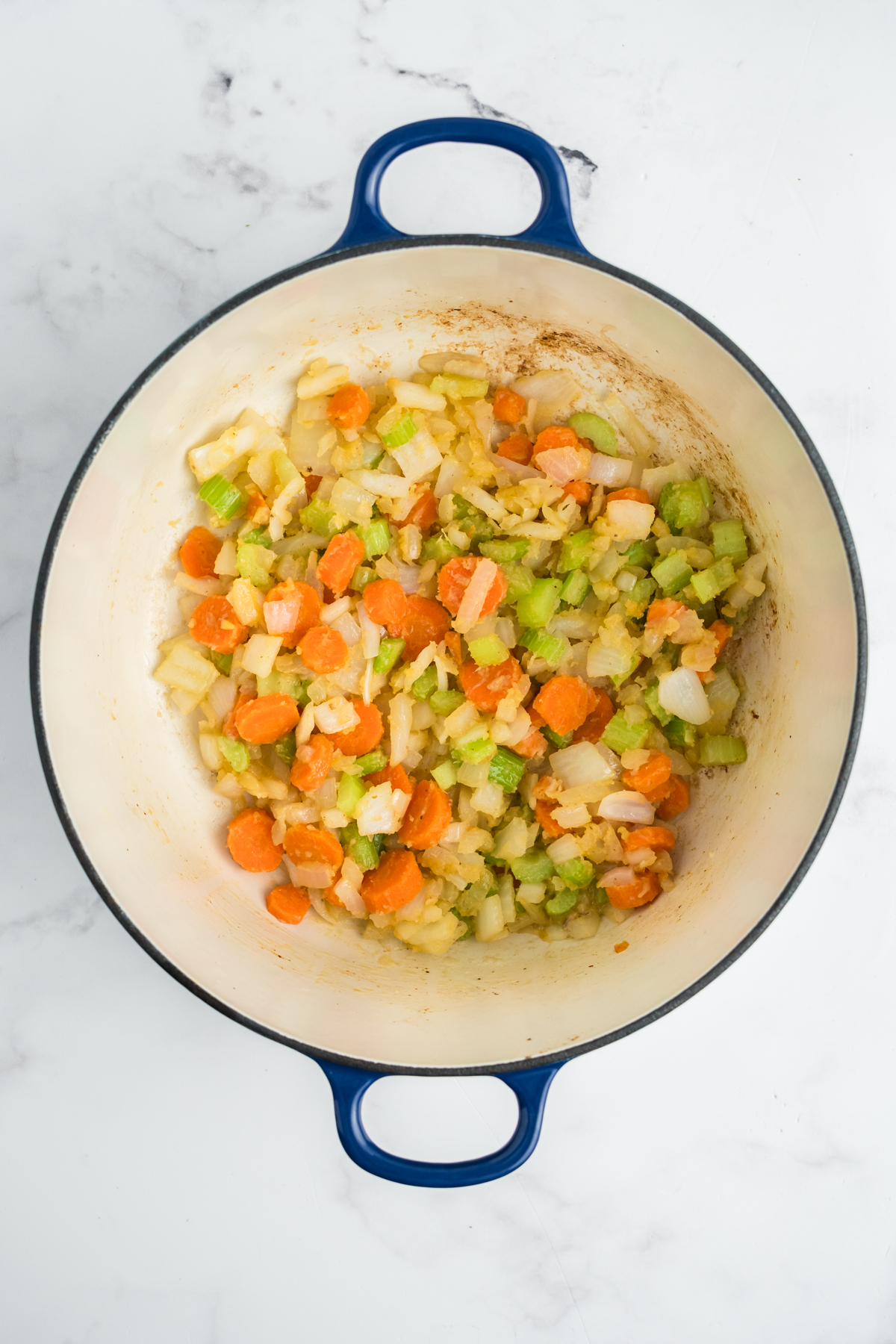 Celery, carrots, and onions cooking in the pot.