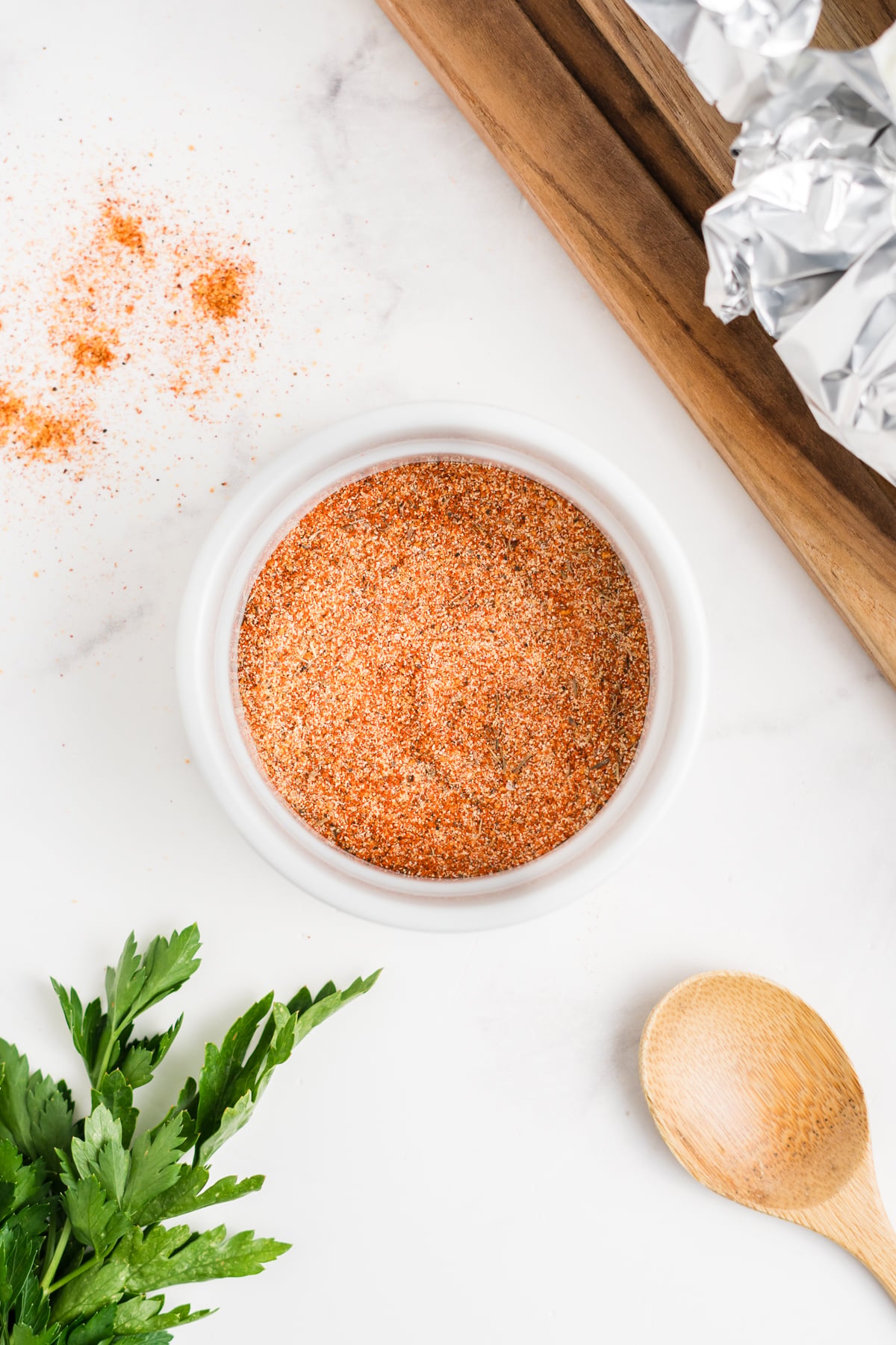 A small bowl filled with paprika, garlic powder, salt, Cajun seasoning, thyme, and black pepper.