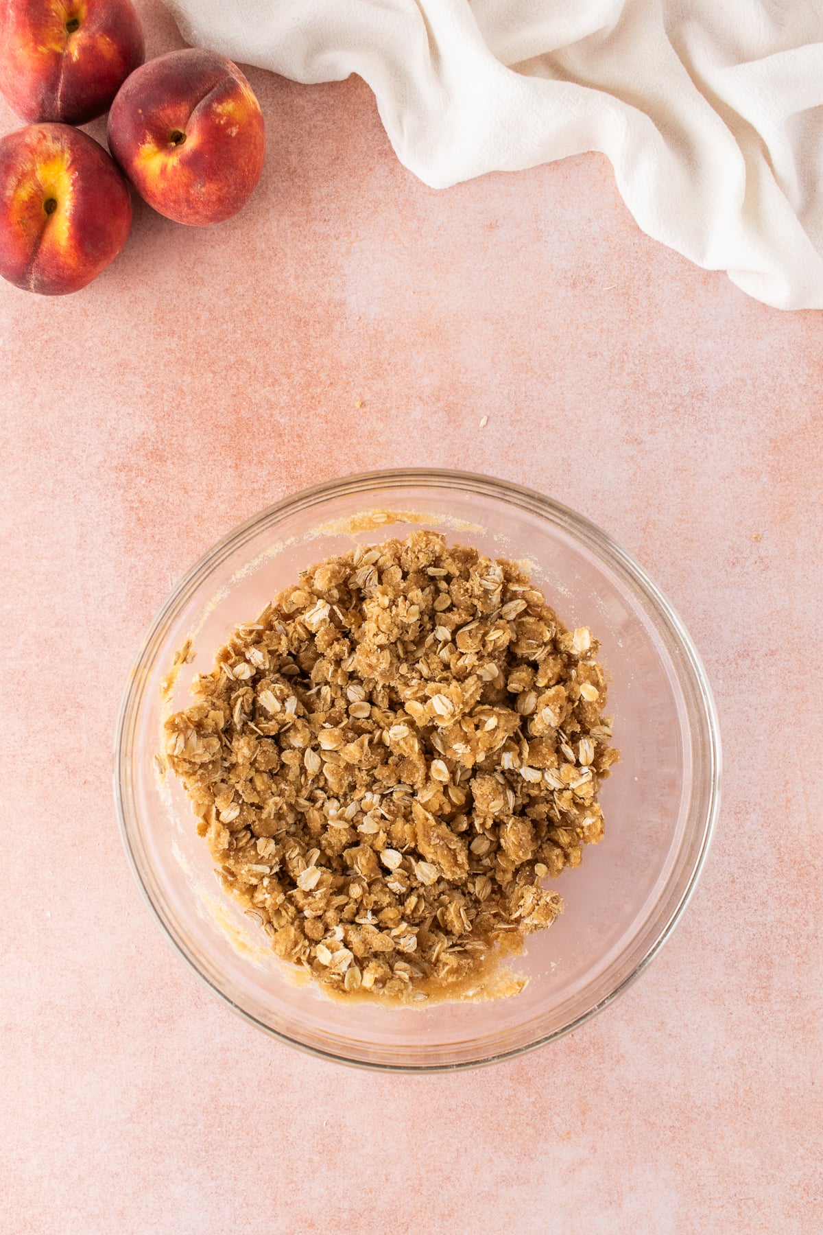 A medium bowl with oats, flour, brown sugar and melted butter.