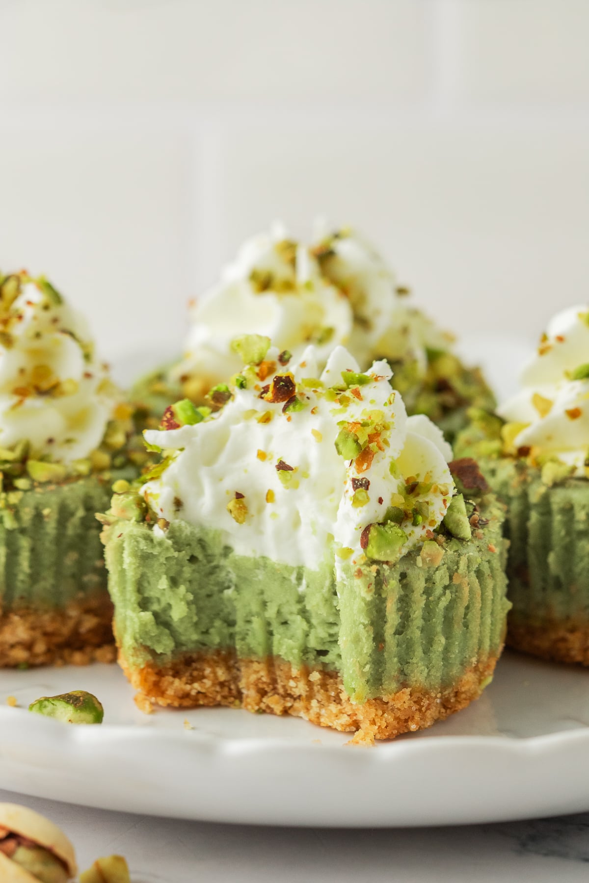 A pistachio cheesecake with a bite taken out of it.