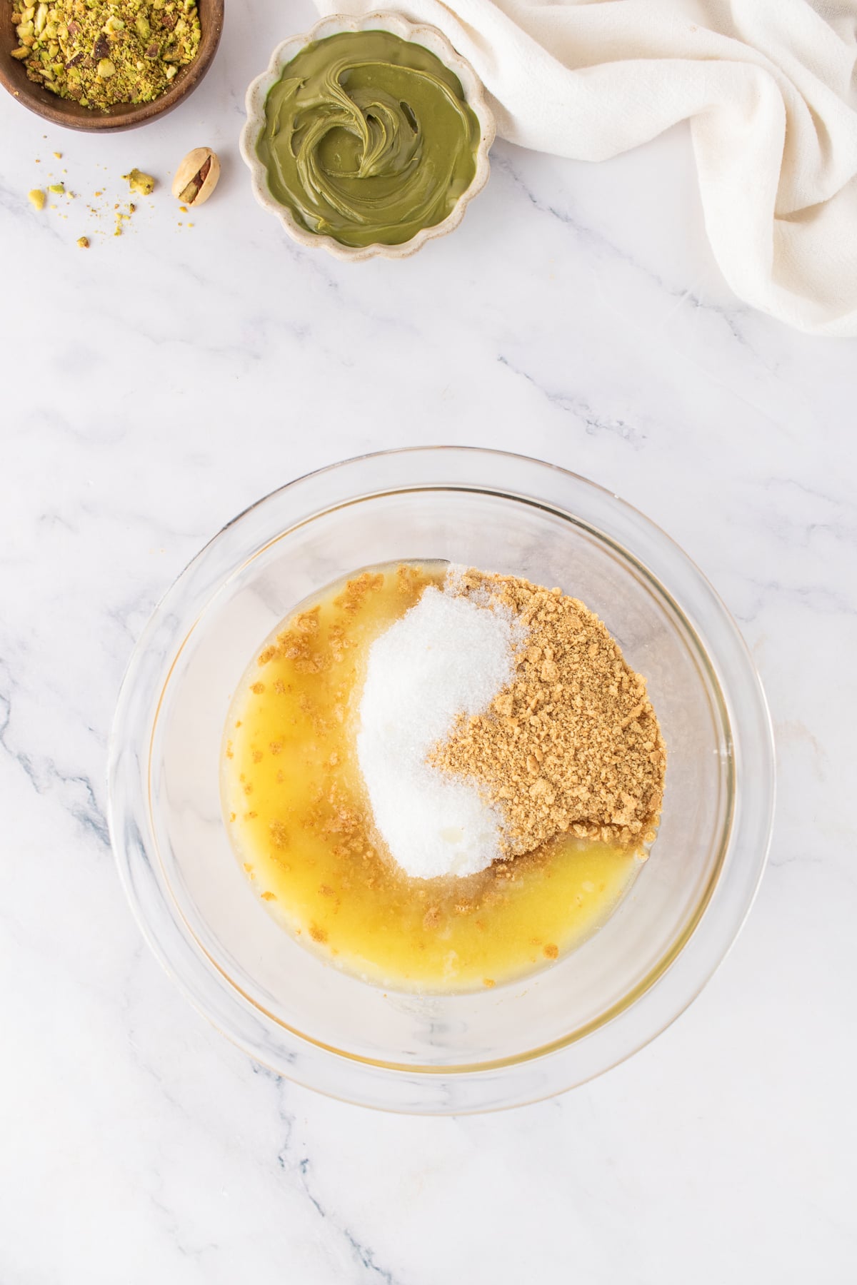 Graham cracker crumbs, melted butter, and sugar in a bowl.