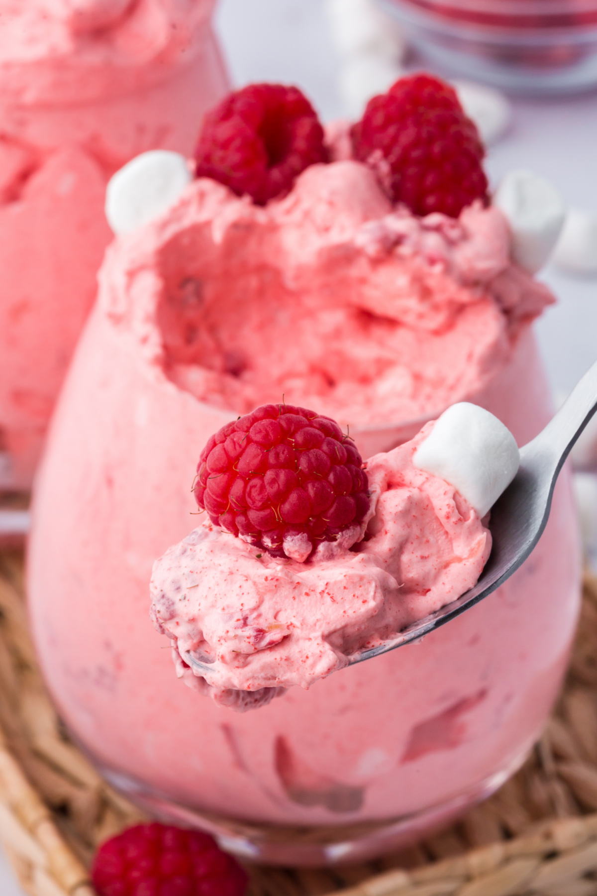a spoonful of raspberry fluff jello salad held above the bowlful