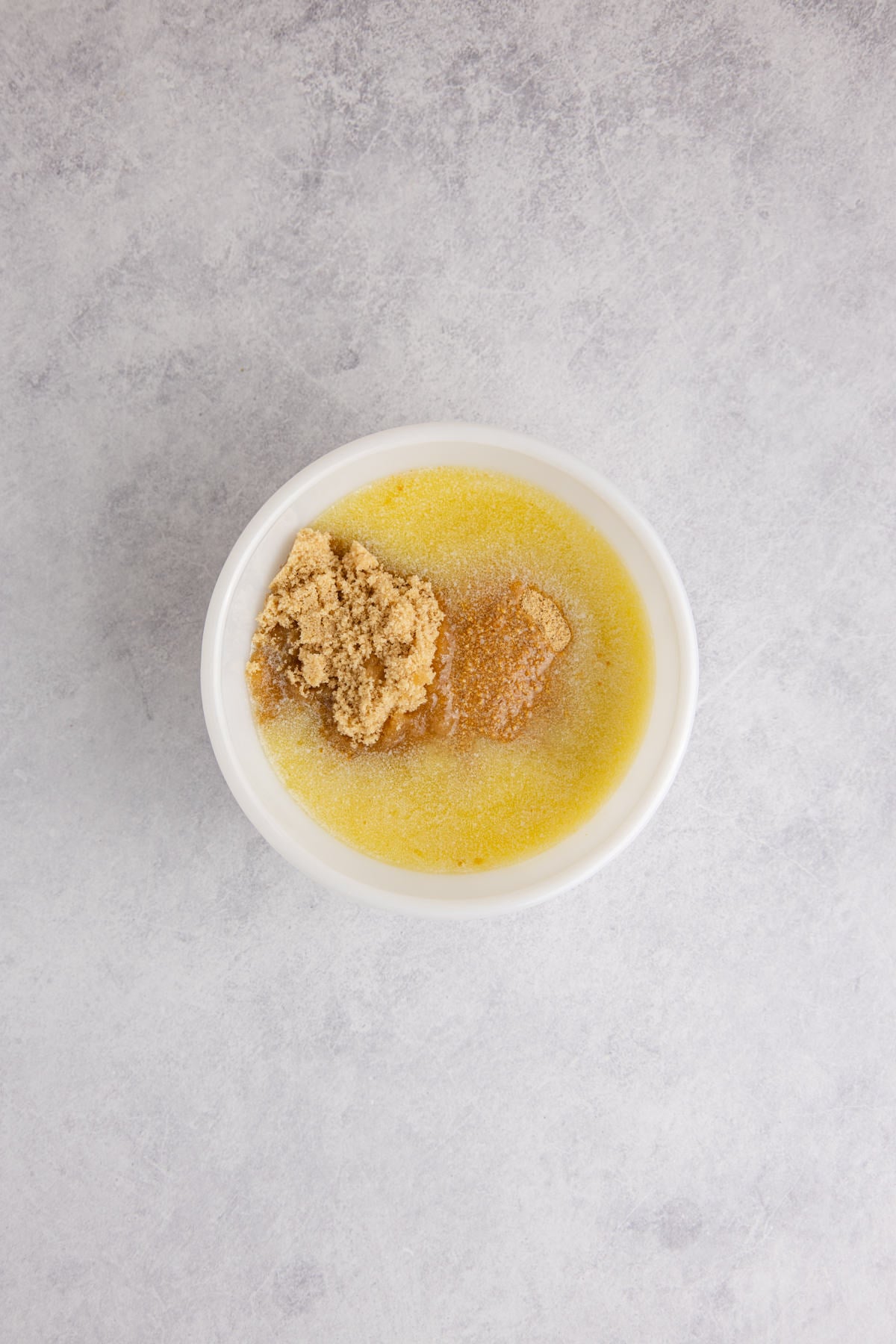 graham cracker crumbs, melted butter and brown sugar in a bowl ready to be mixed