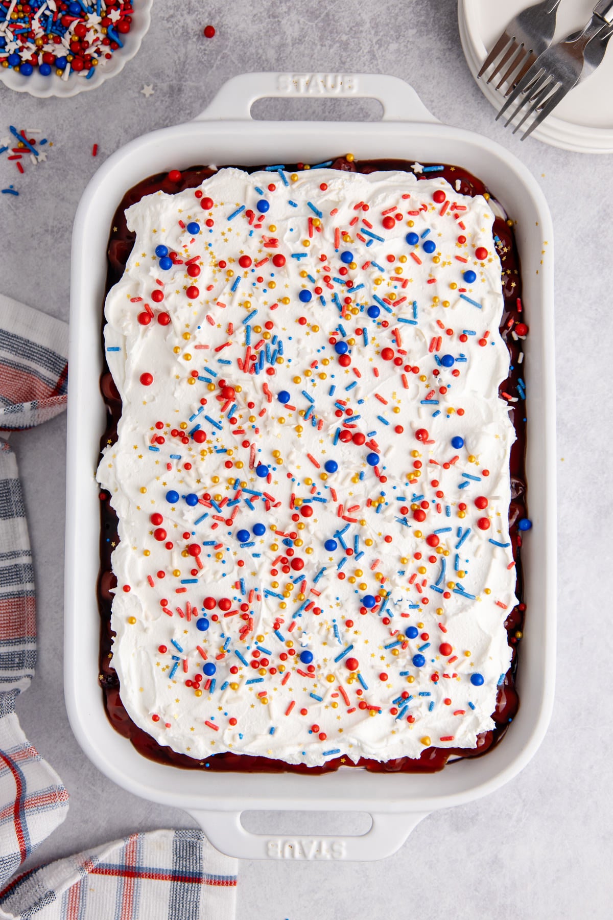 layered blueberry pie filling, cream cheese mixture, cherry pie filling, topped with Cool Whip and sprinkles