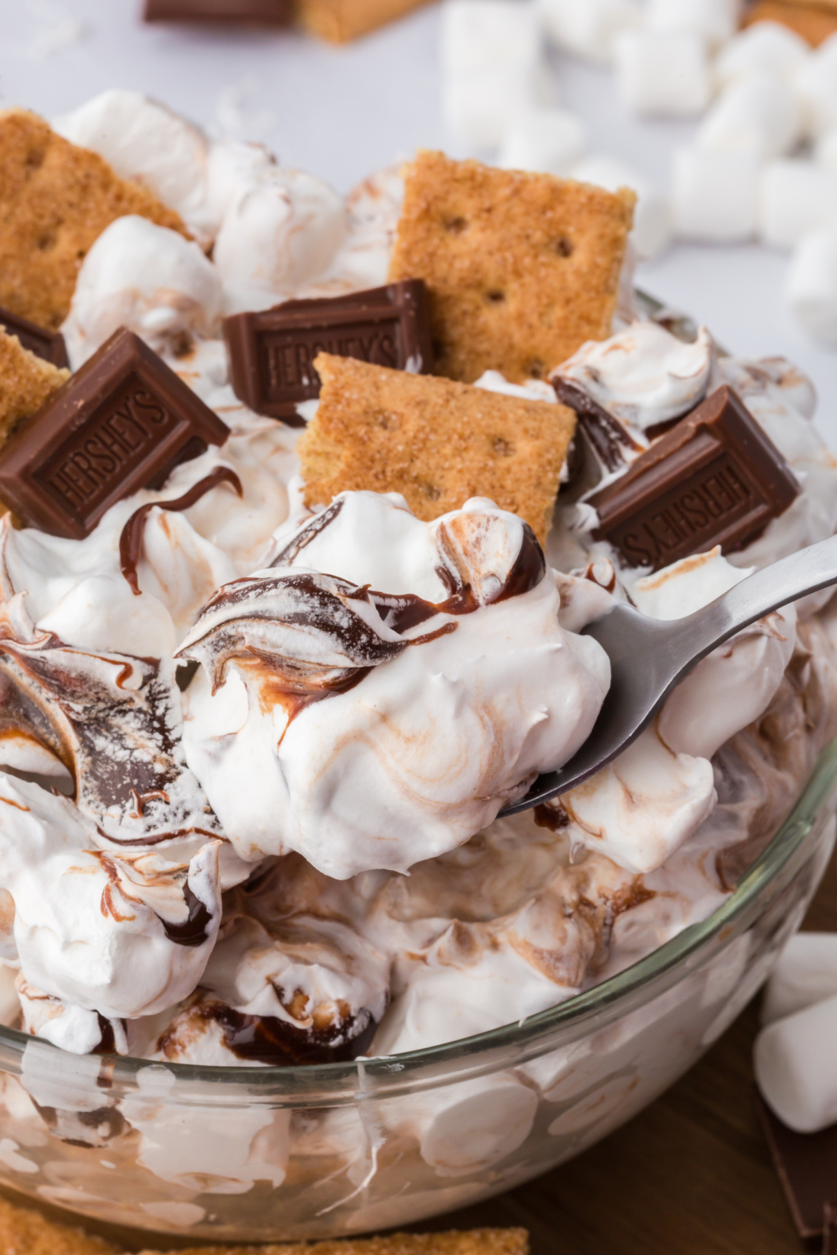 A bowl of s'mores fluff with a spoonful being lifted up out of the bowl.
