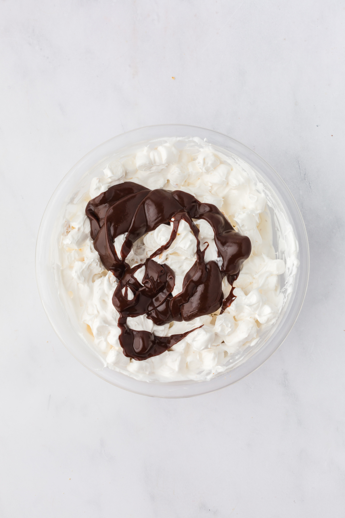 Chocolate fudge is added to bowl.