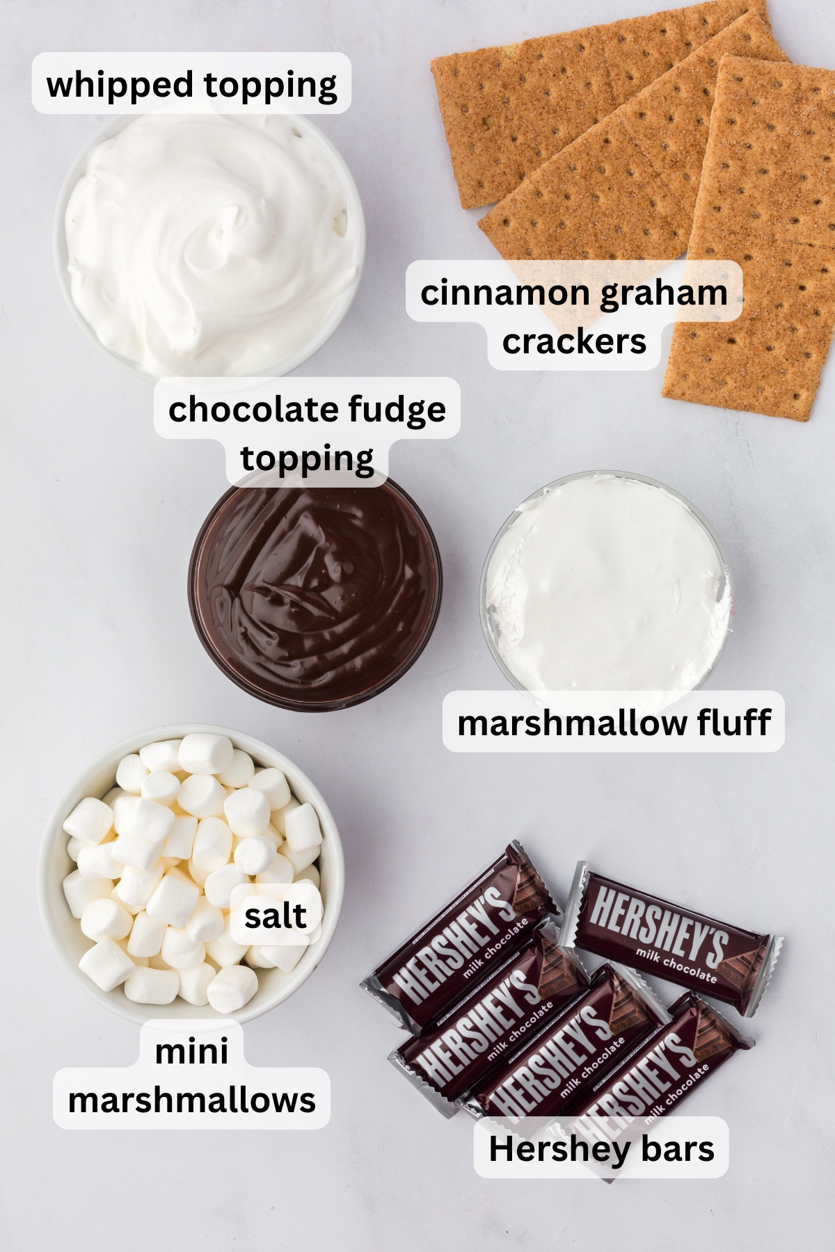 All of the ingredients needed to make S'mores Fluff in bowls on a table.