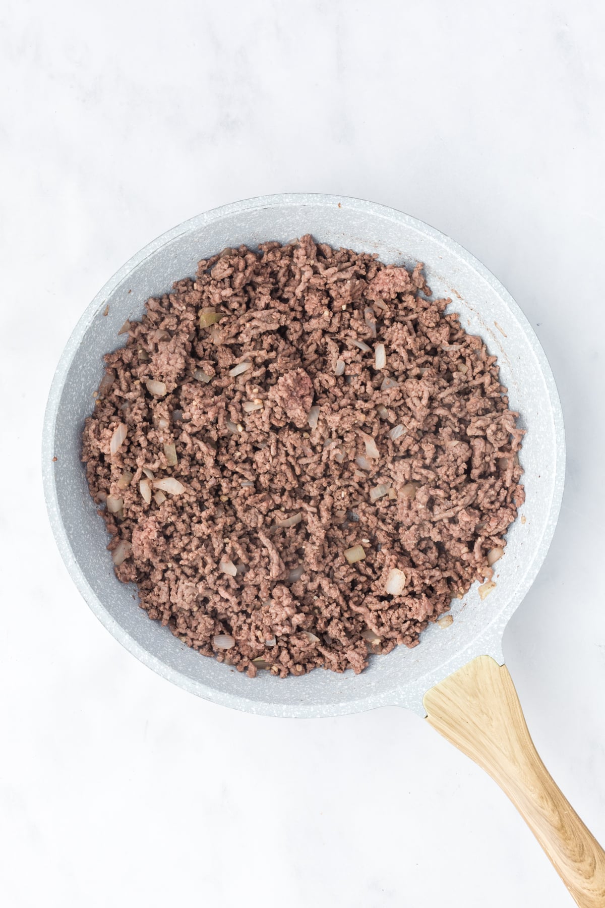 Ground beef cooking in the pan.