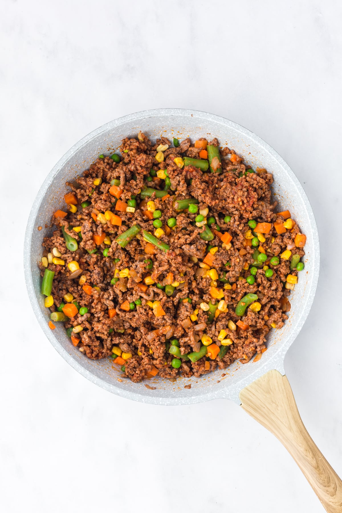 Frozen veggies added to the ground beef mixture.