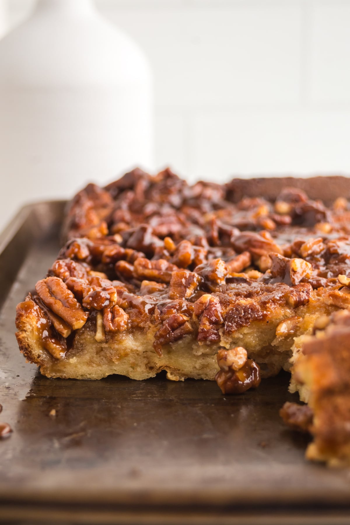 Bread pudding on a tray with pecans on top.