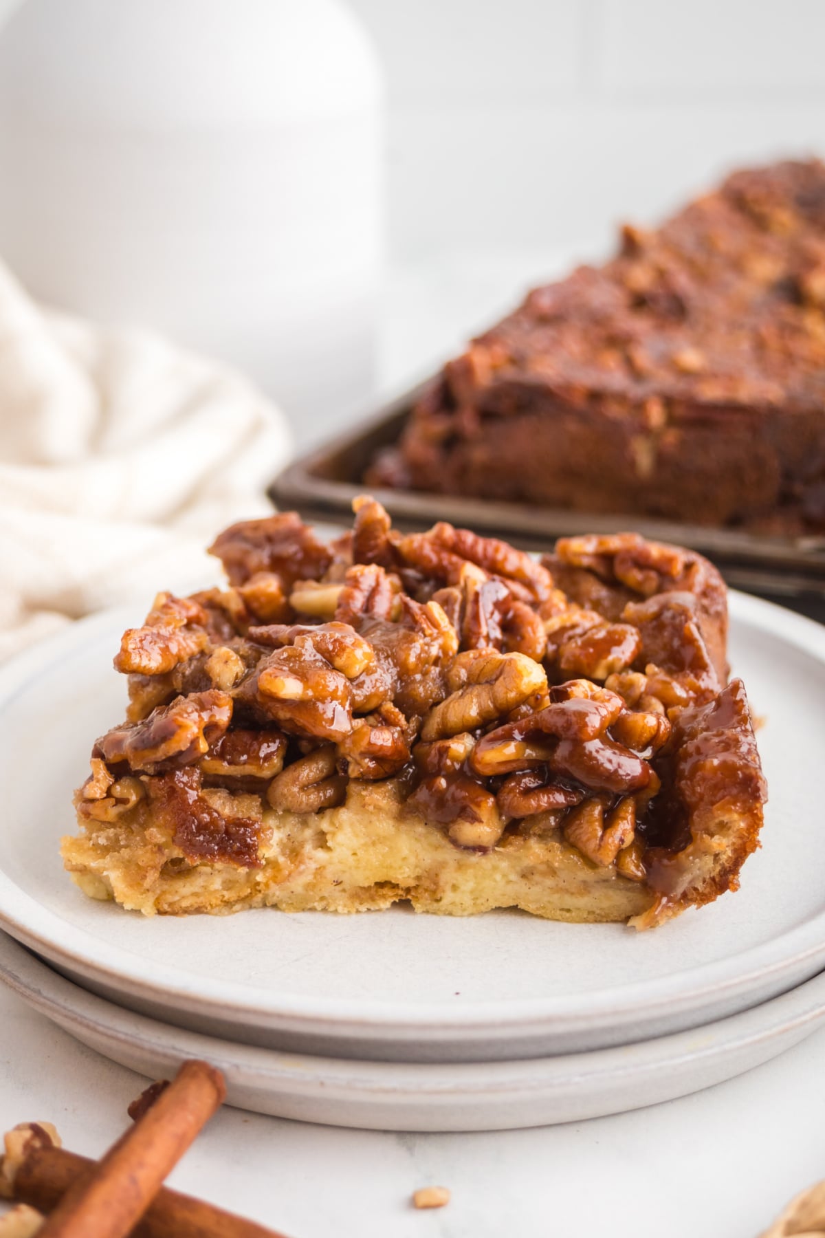 A slice of pecan bread pudding on a white plate.
