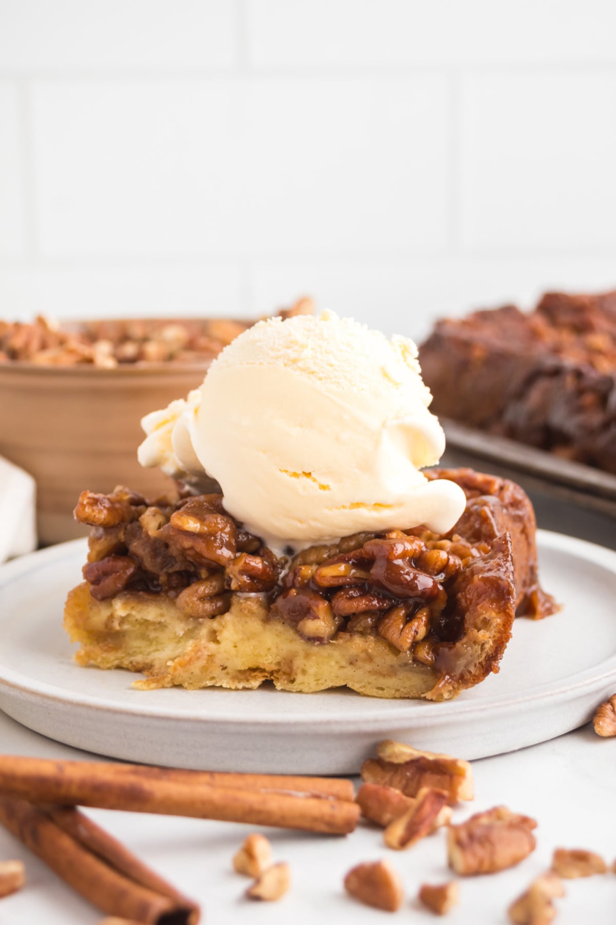 Bread pudding with pecans and ice cream on top.
