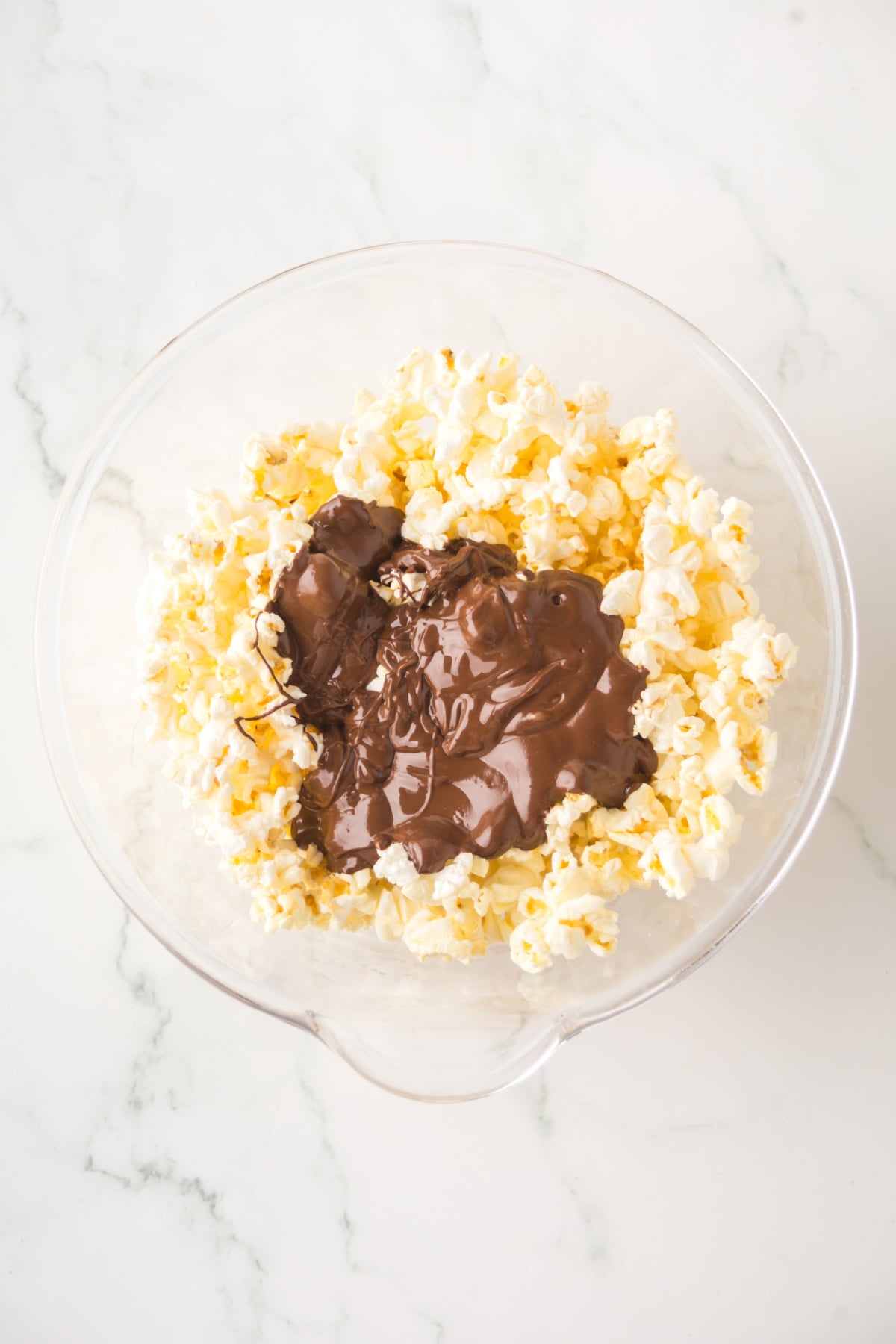 Melted chocolate mixture is poured over the popcorn.