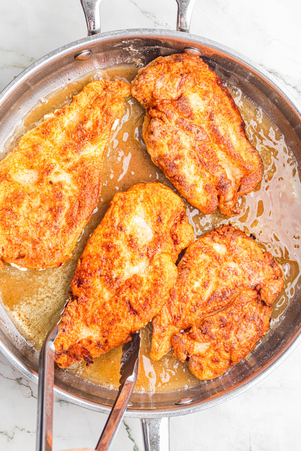The chicken flipped in the skillet.