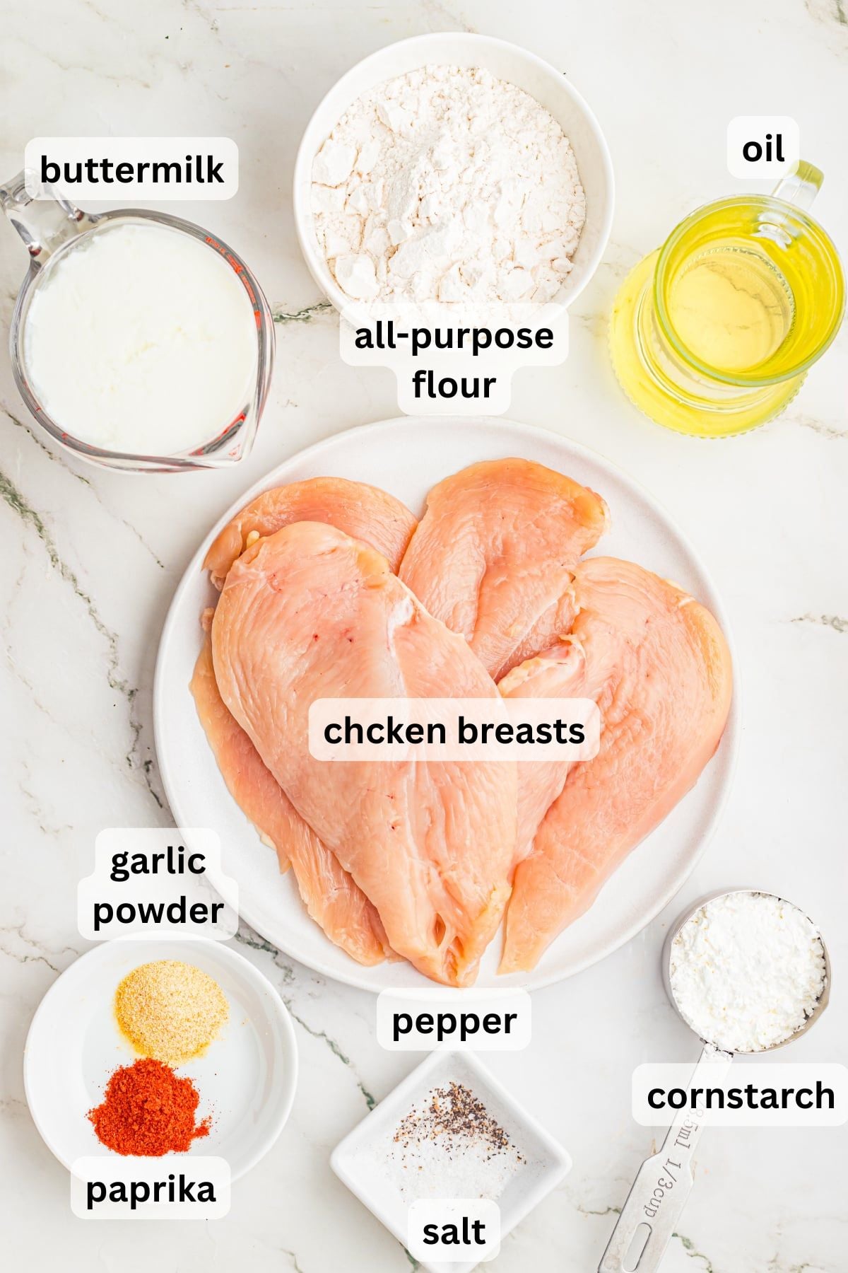 Ingredients to make these fried chicken breast on a table.