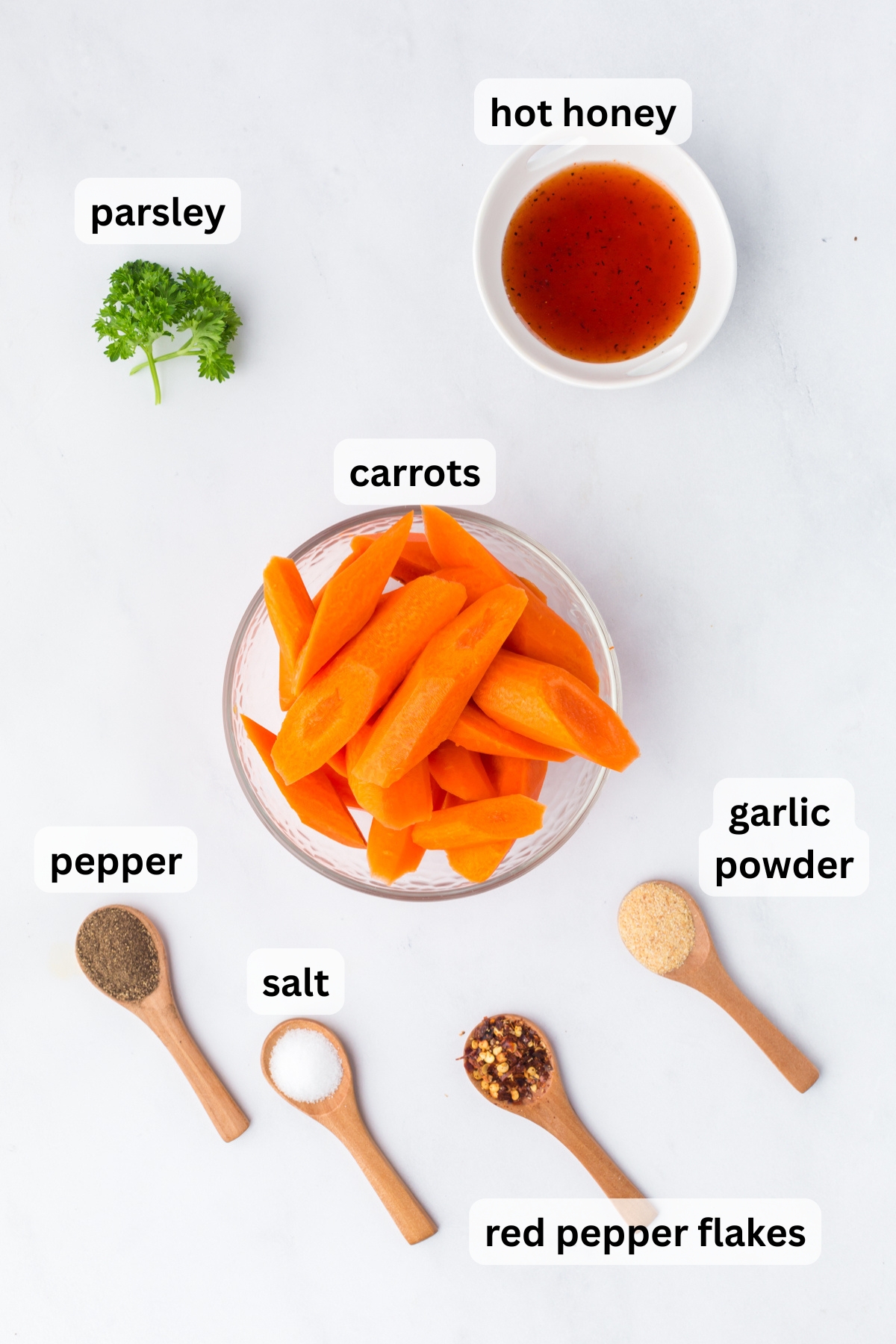 All of the ingredients needed to make hot honey carrots in bowls on a table
