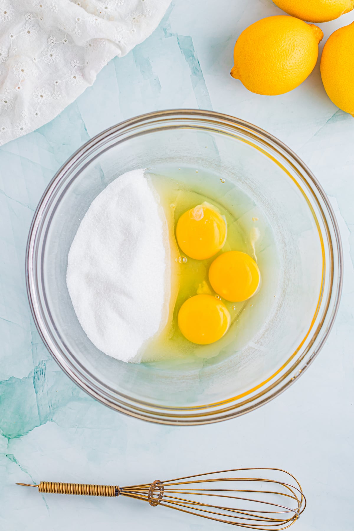 The eggs and sugar in a mixing bowl.
