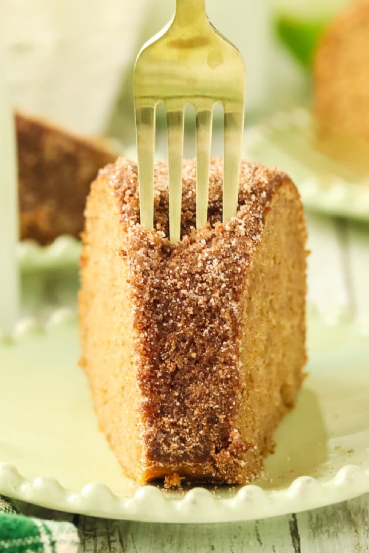 A fork pressing into a slice of cake on a dessert plate.