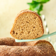 Slice of Apple Cider Cake Recipe being lifted with a spatula above the cake.
