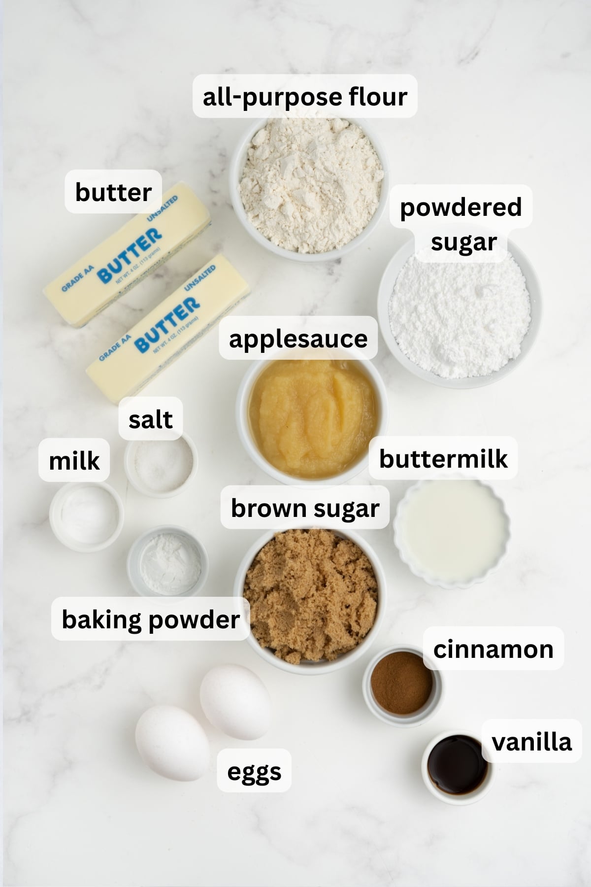 All of the ingredients needed to make apple crumb cake in bowls on a table.