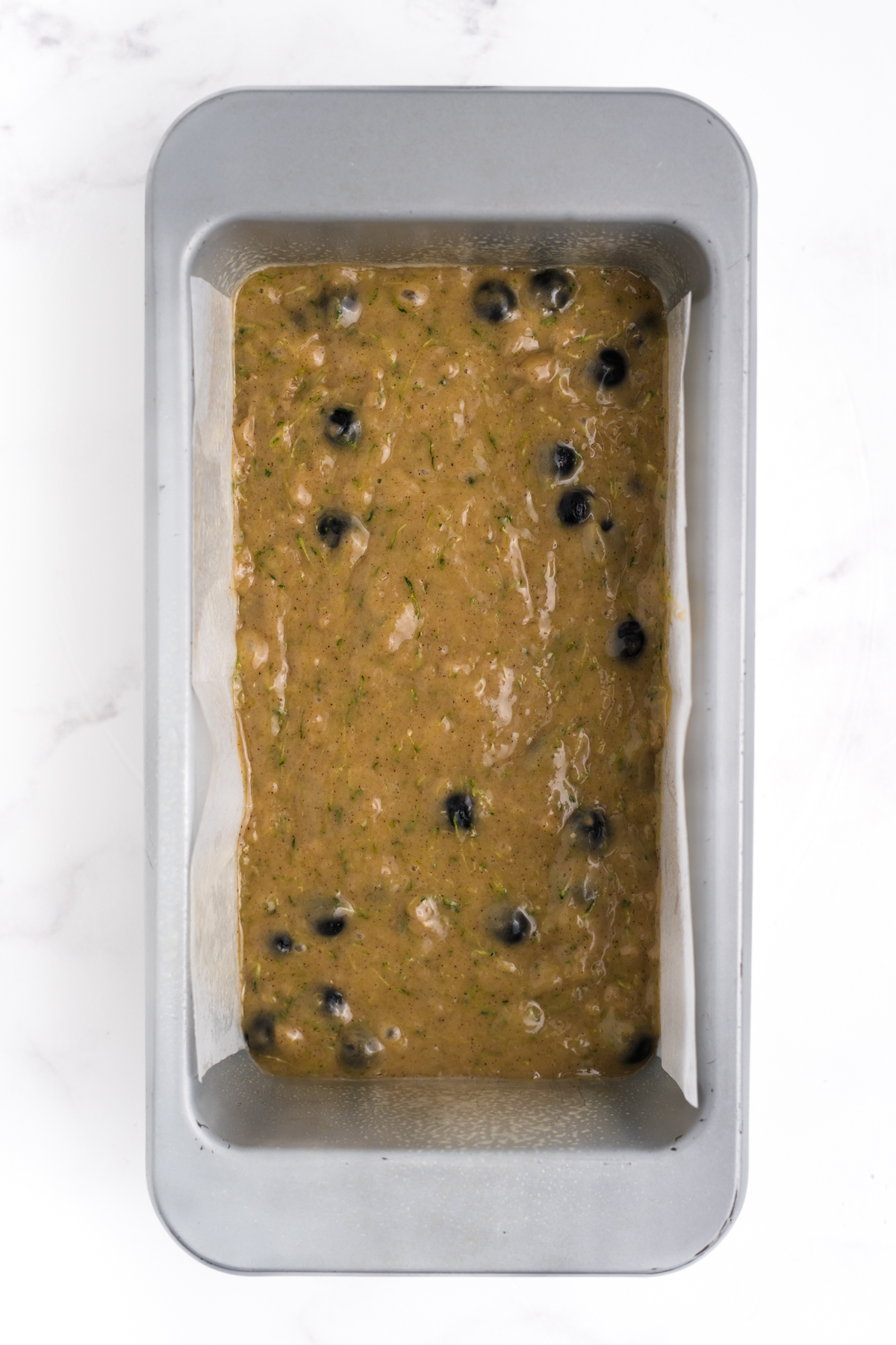 Batter filled loaf pan ready for crumble topping.
