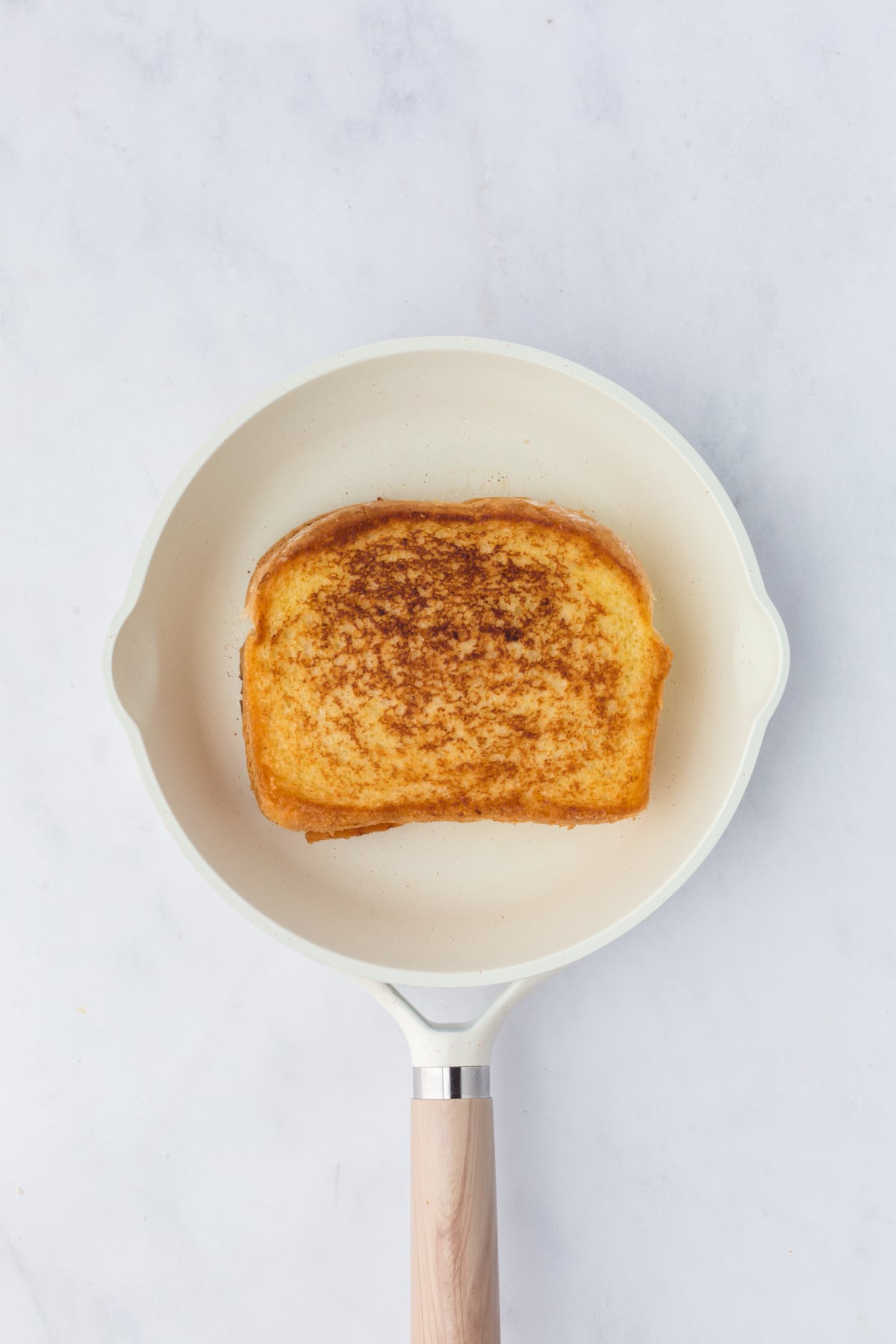 Golden brown sandwich in skillet.