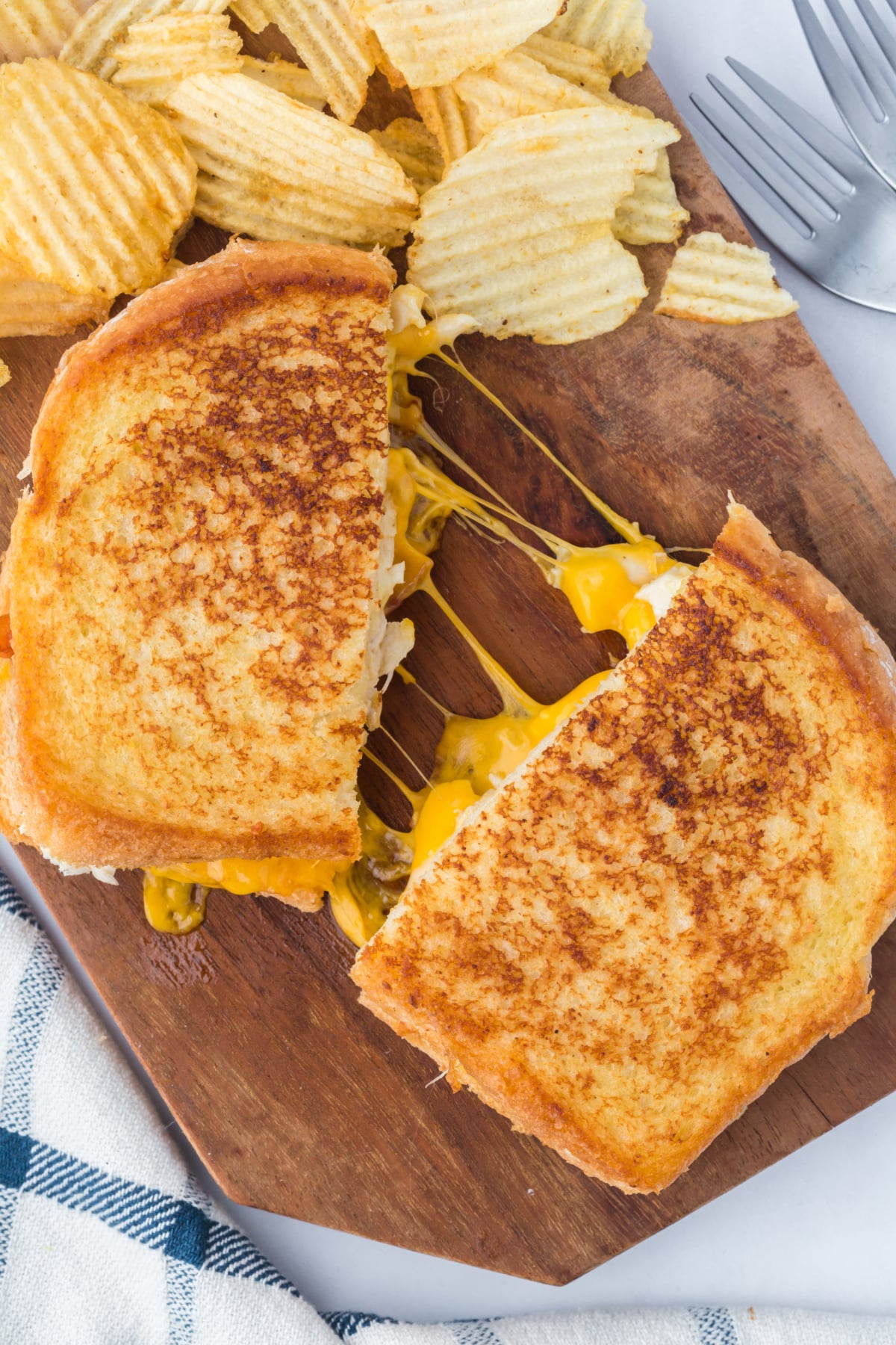 Grilled cheese cut in half on a cutting board.