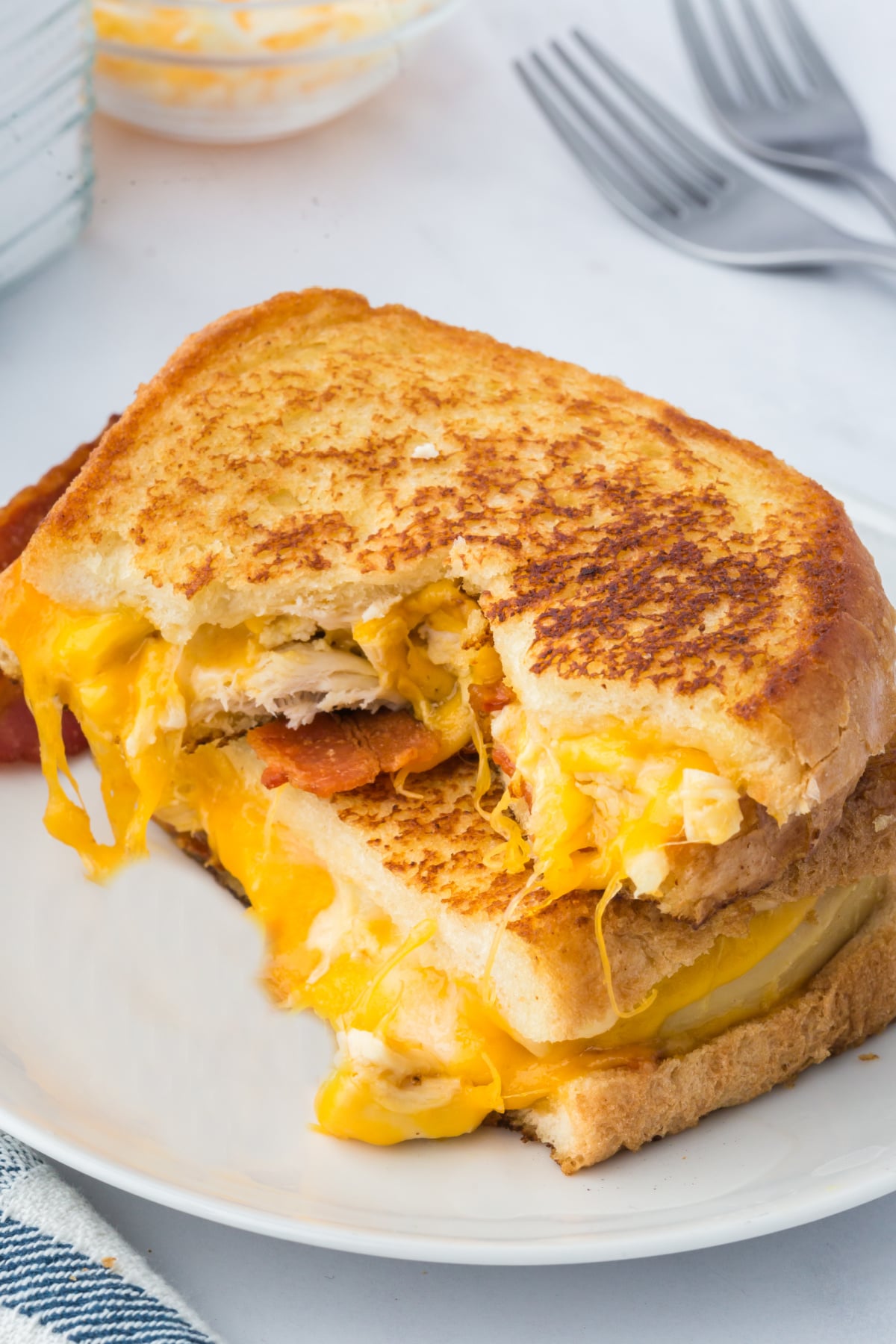 Two halves of Grilled Cheese stacked on a plate.