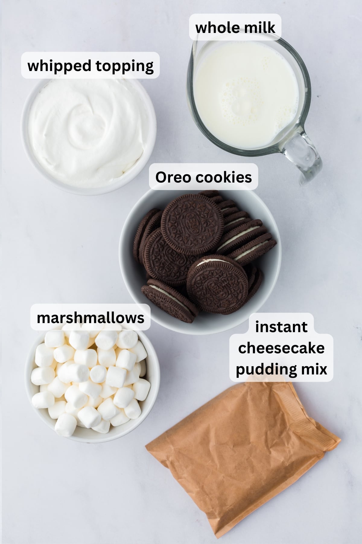 Ingredients needed to make Cookies and Cream Fluff in bowls on a table.