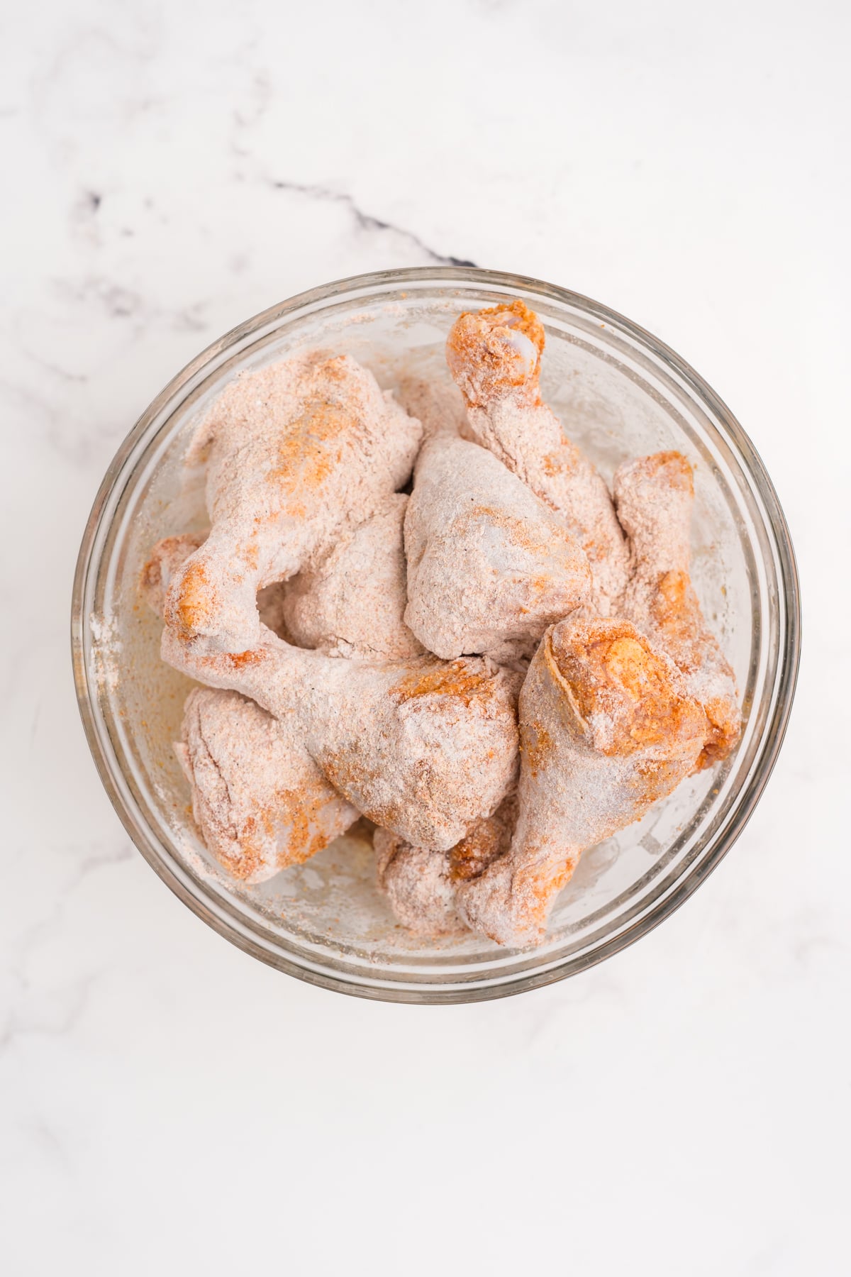 The mixture coated on the chicken in the bowl.