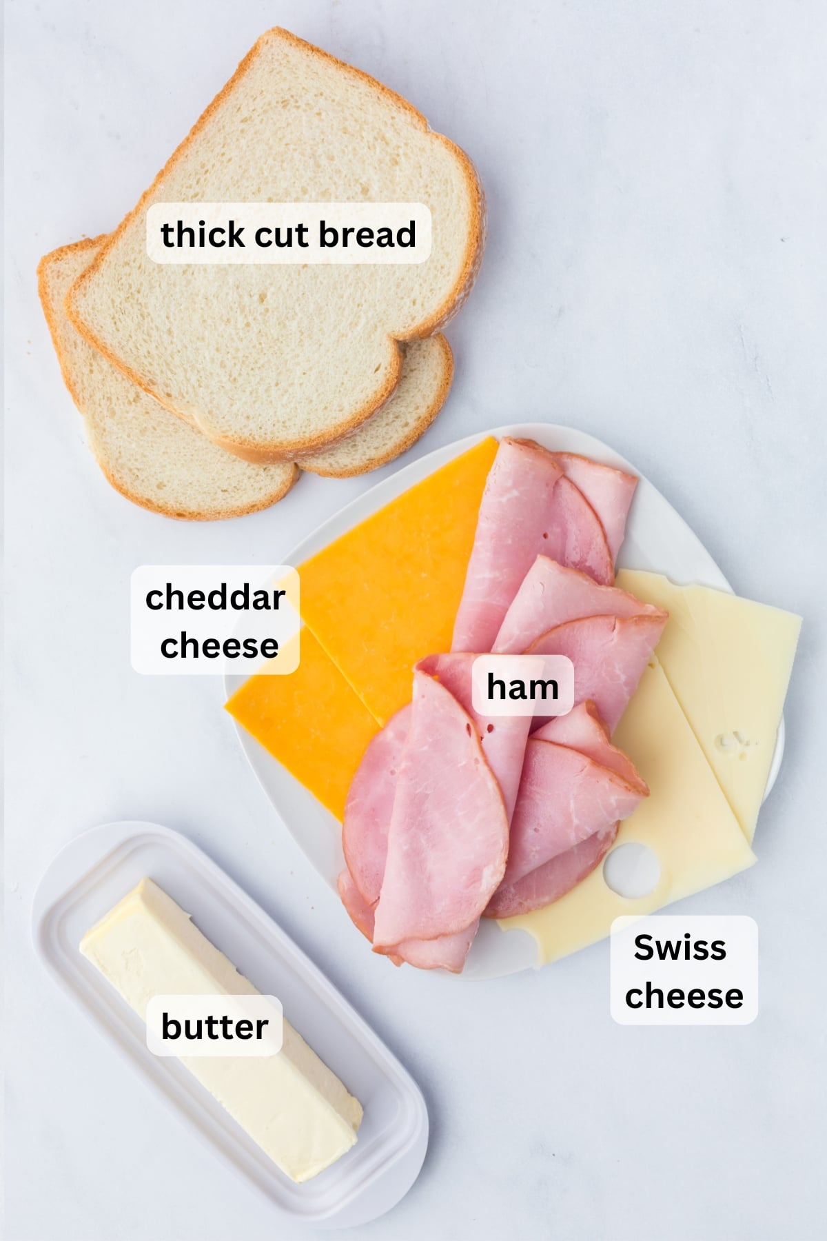 Ingredients needed to make a Grilled Ham and Cheese Sandwich arranged on a table.