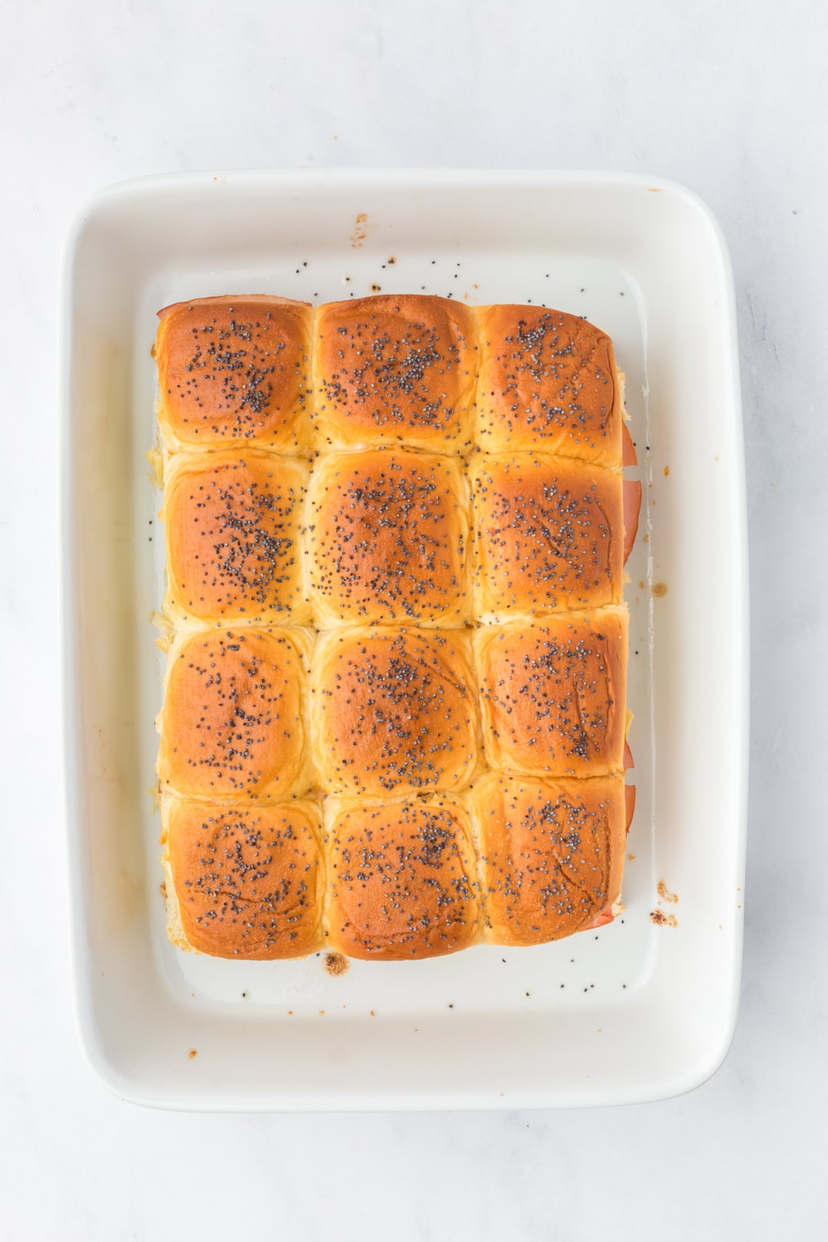 Sliders baked until golden with melted cheese and buttery seed covered tops.