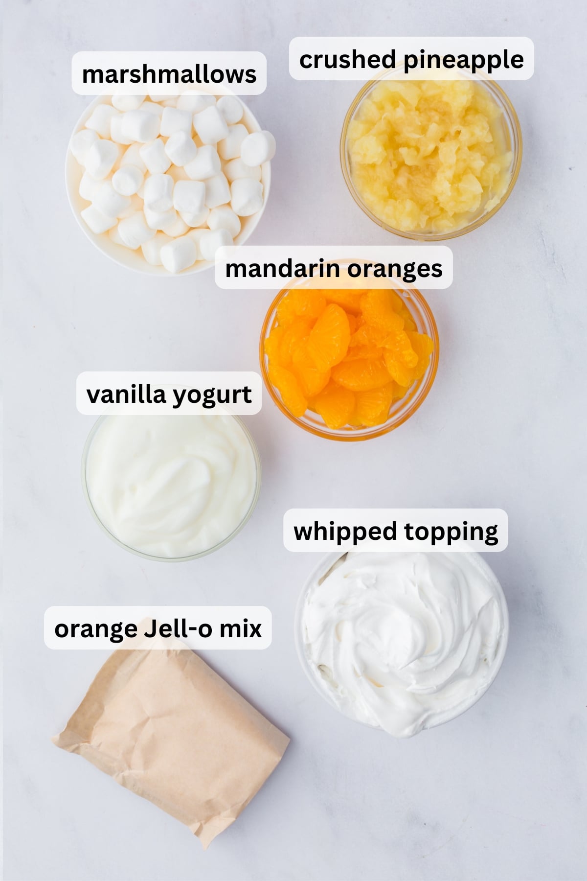 All of the ingredients needed to make Mandarin Orange Fluff in bowls on a table.
