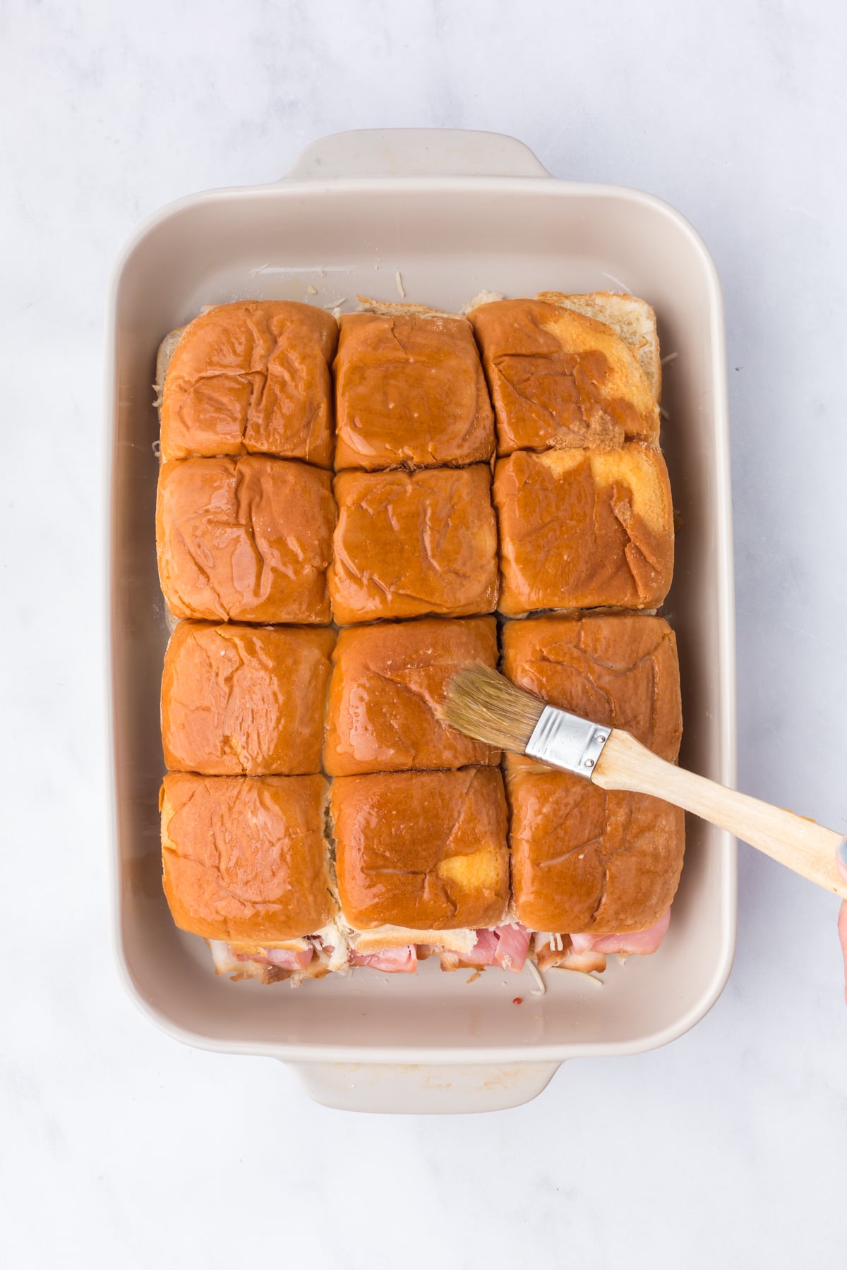 Butter and Dijon topping brushed over assembled Sliders.