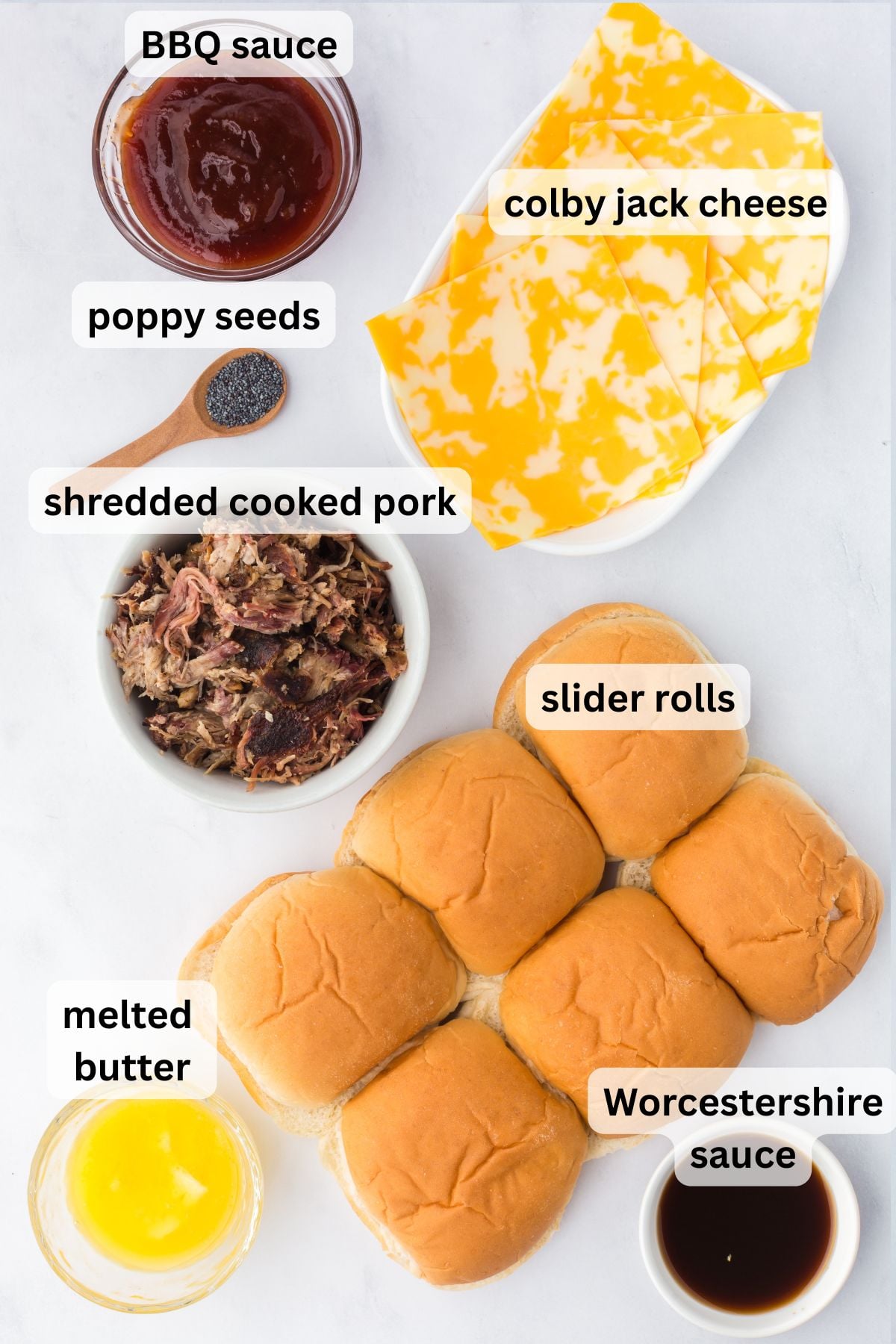 All of the ingredients needed to make  Pulled Pork Sliders in bowls on a plate.