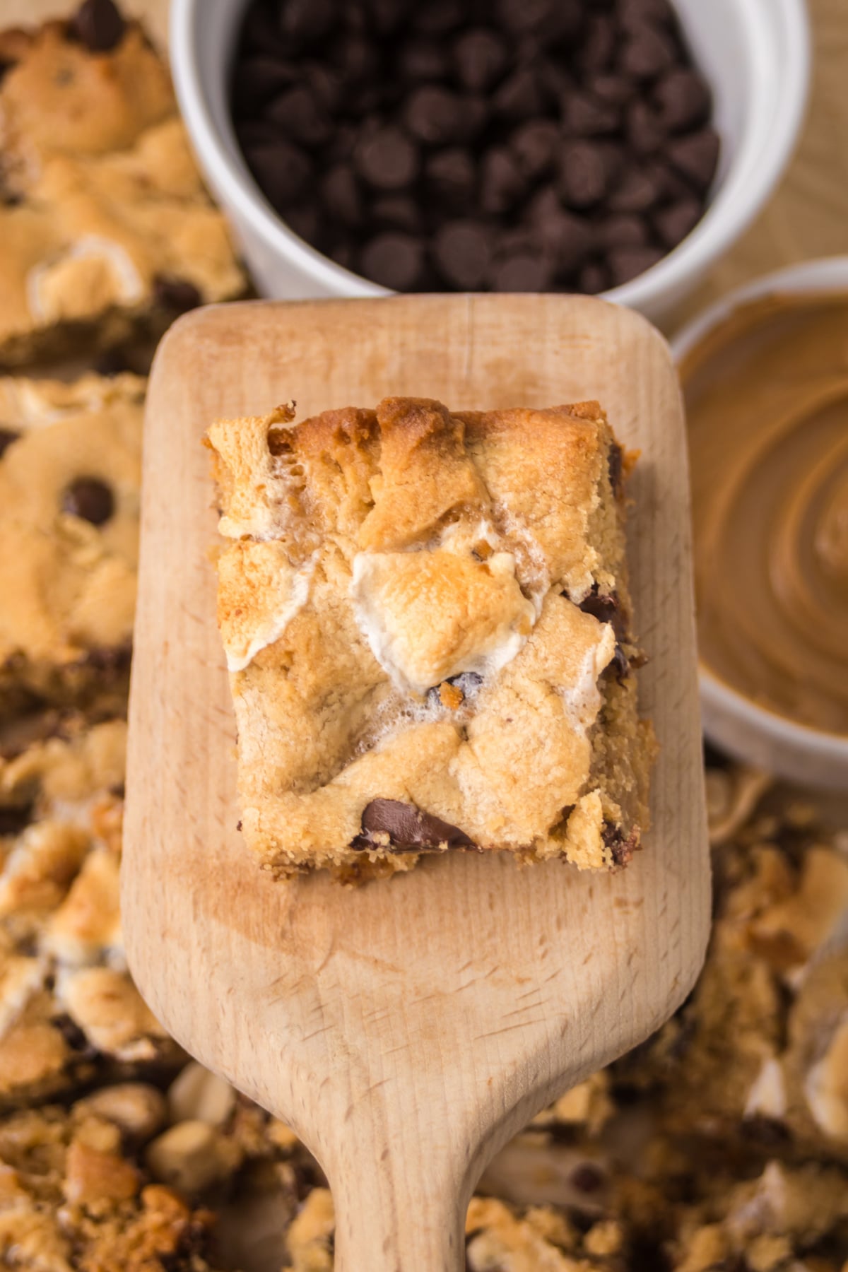 bar with gooey marshmallows and chocolate chips on spatula held in the air.