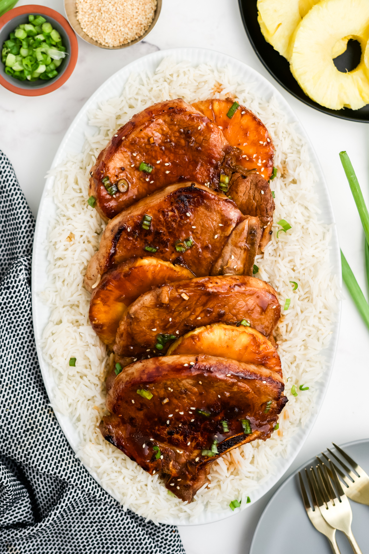 Pork chops and pineapple slices on a bed of rice.