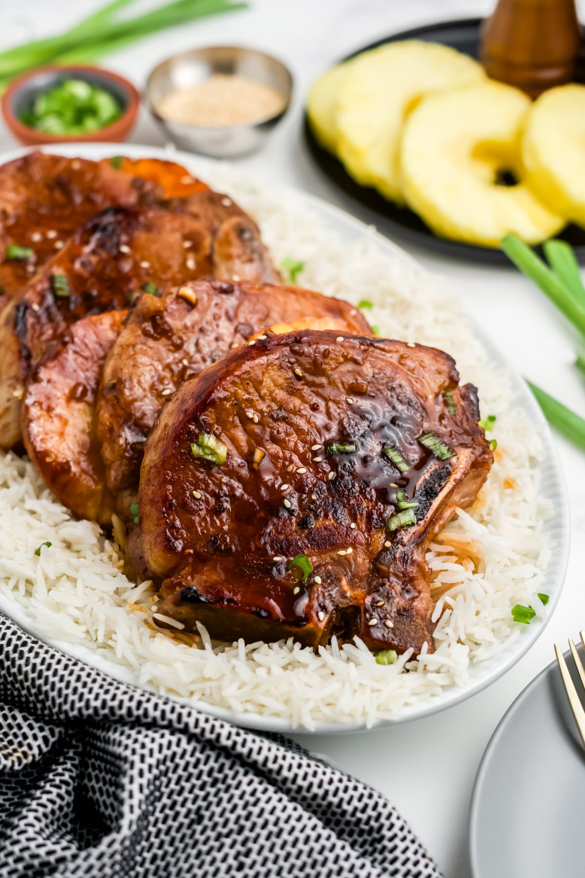 Teriyaki pork chops over a plate of rice.