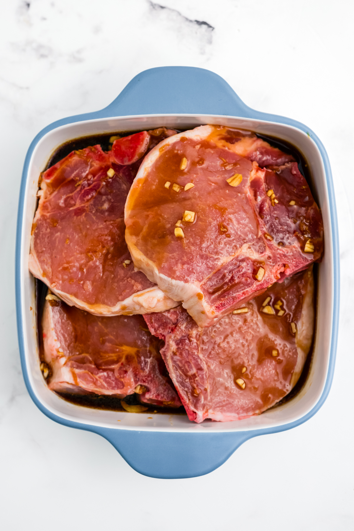 The pork chops sitting in the marinade.