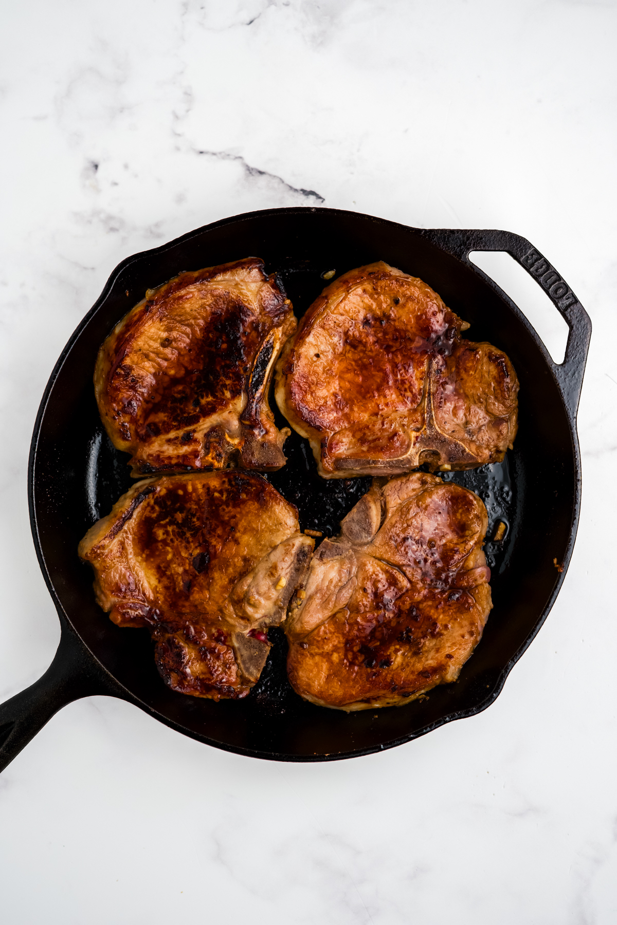 The pork chops in a pan.