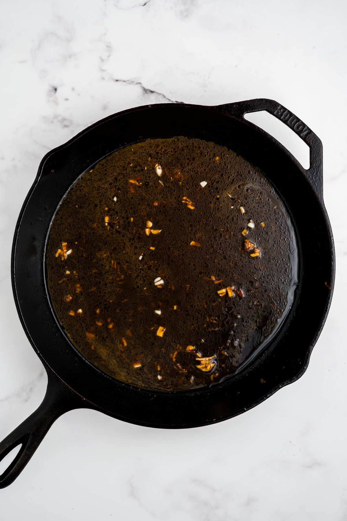 The sauce being thickened in the skillet.